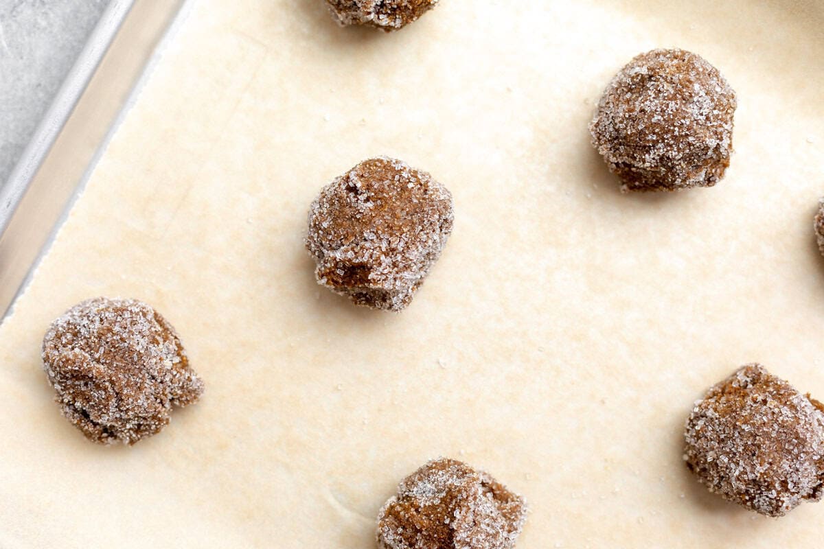 cookie dough balls on a baking sheet before baking