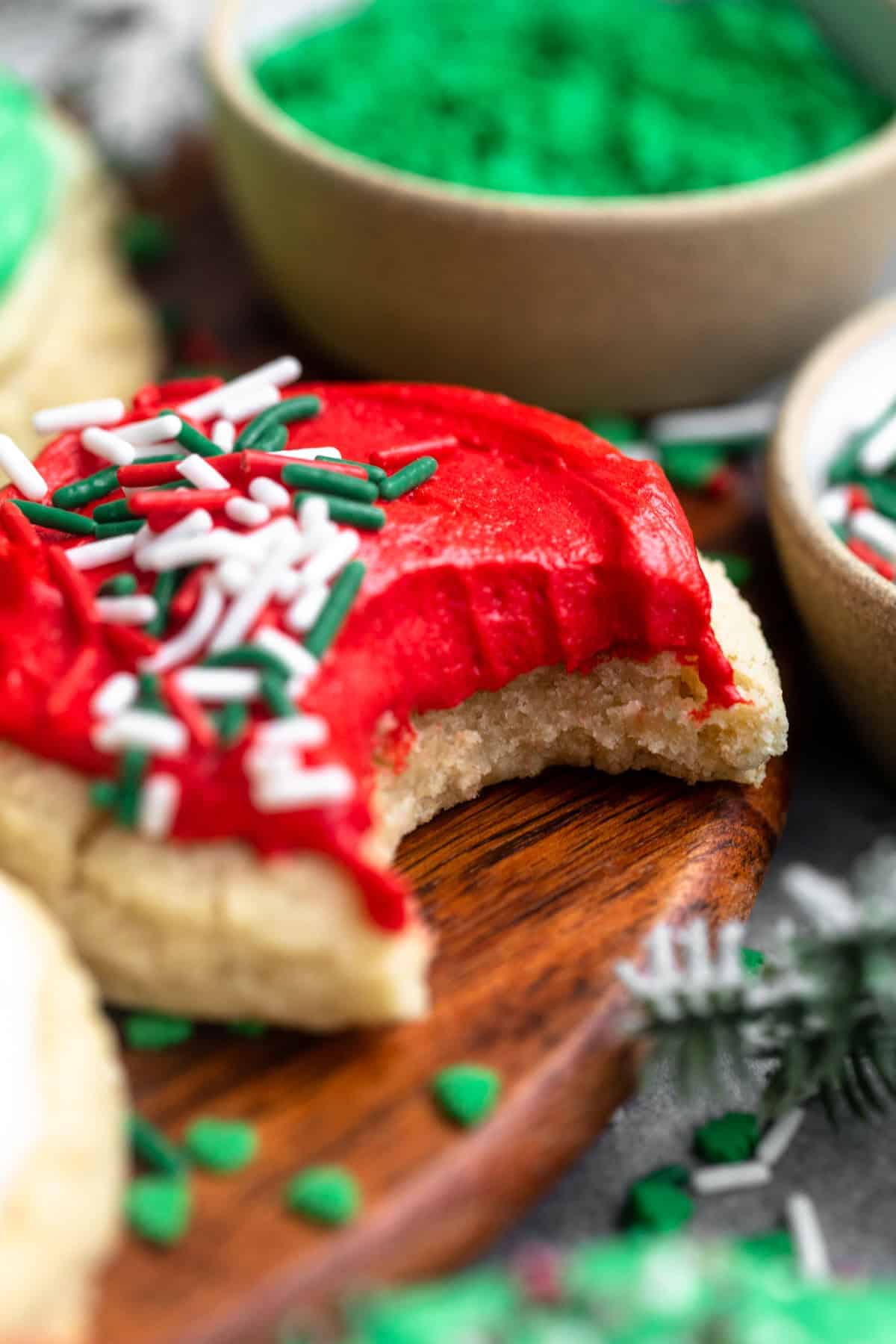 bite taken out of the gluten free christmas cookies with red frosting