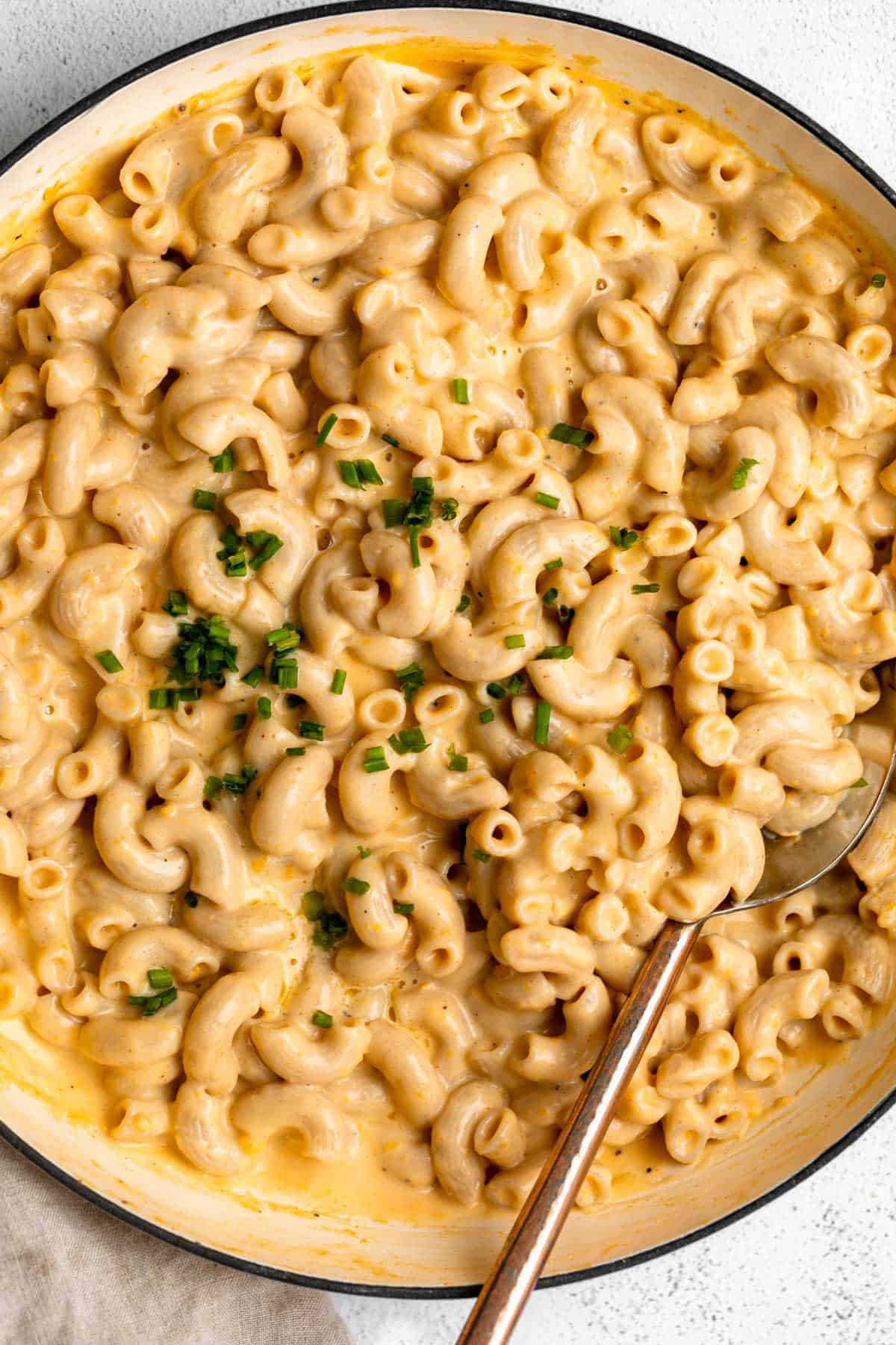 high protein mac and cheese in a pan with chives on top