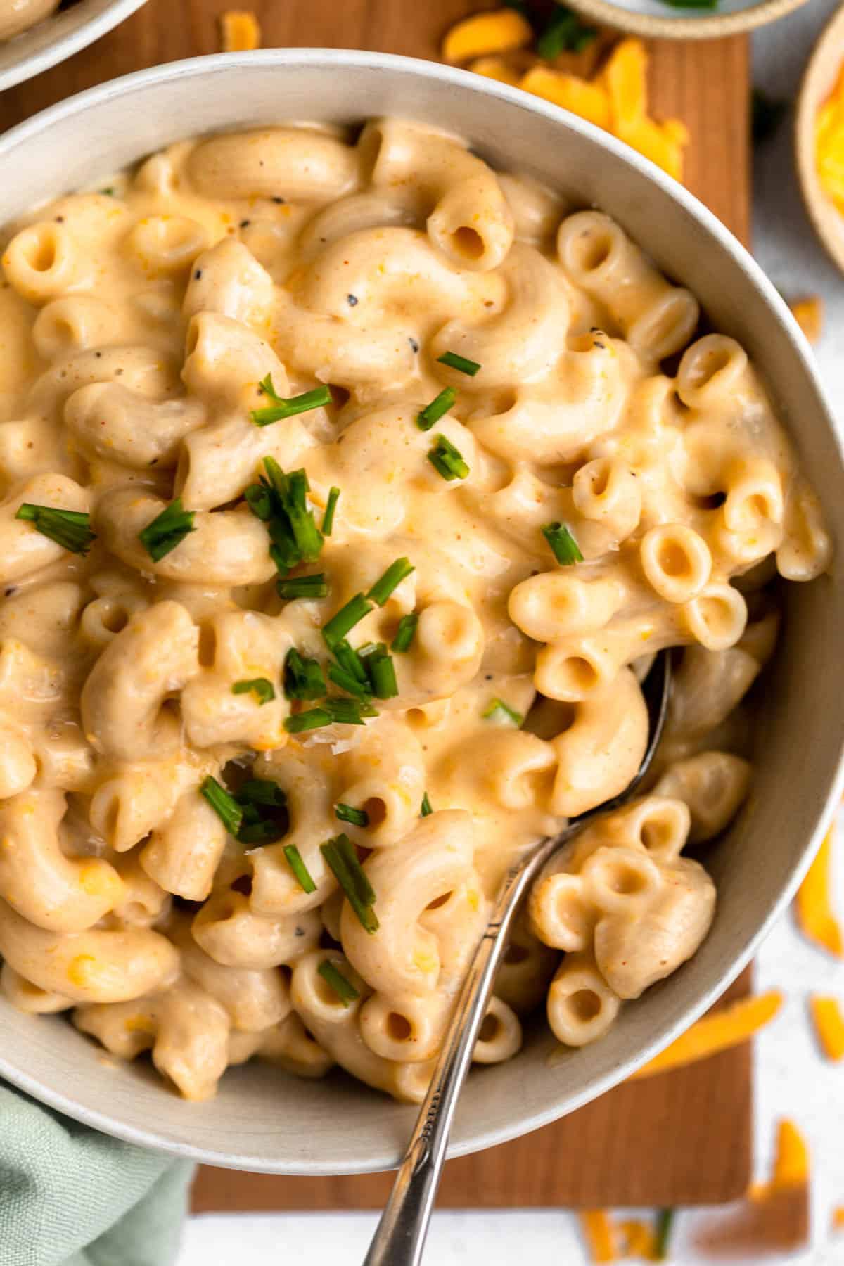 high protein mac and cheese in a bowl with a spoon on the side