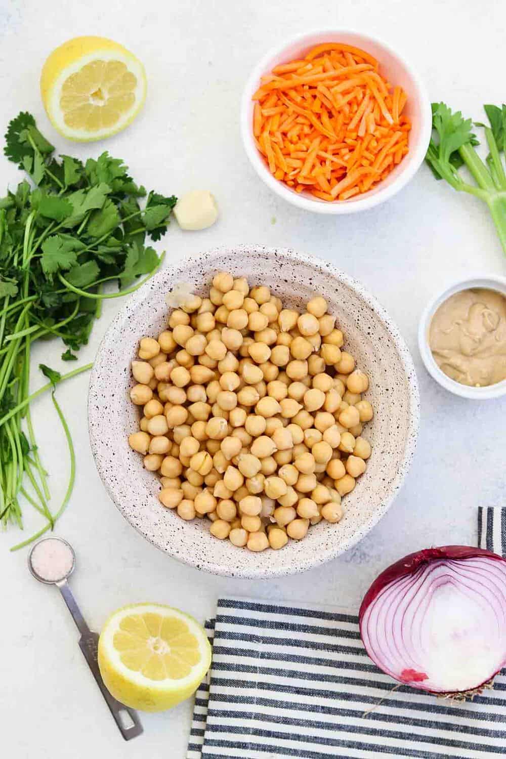 Ingredients for the chickpea salad arranged on a white backdrop. 