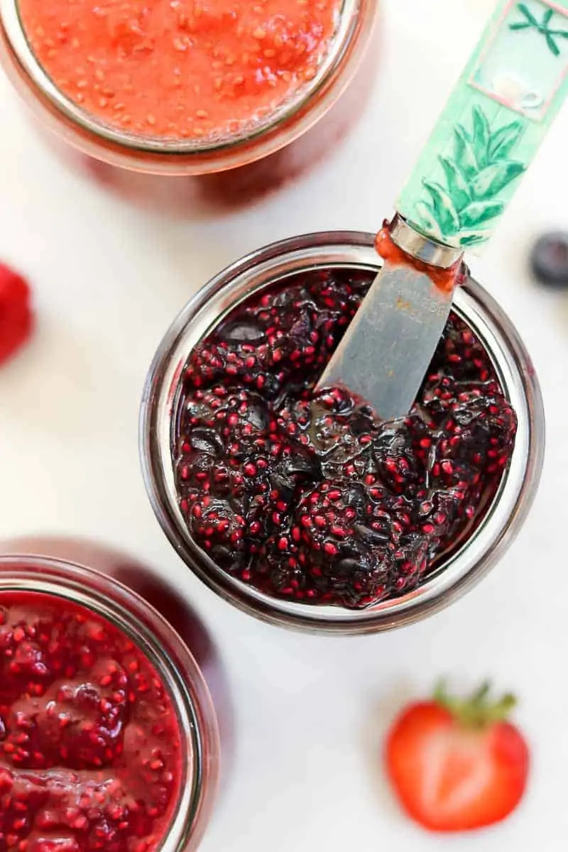Up close of blackberry chia jam with a small knife. 