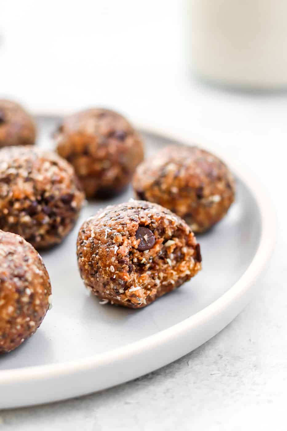 almond butter Energy balls on a blue plate with a bite taken out. 