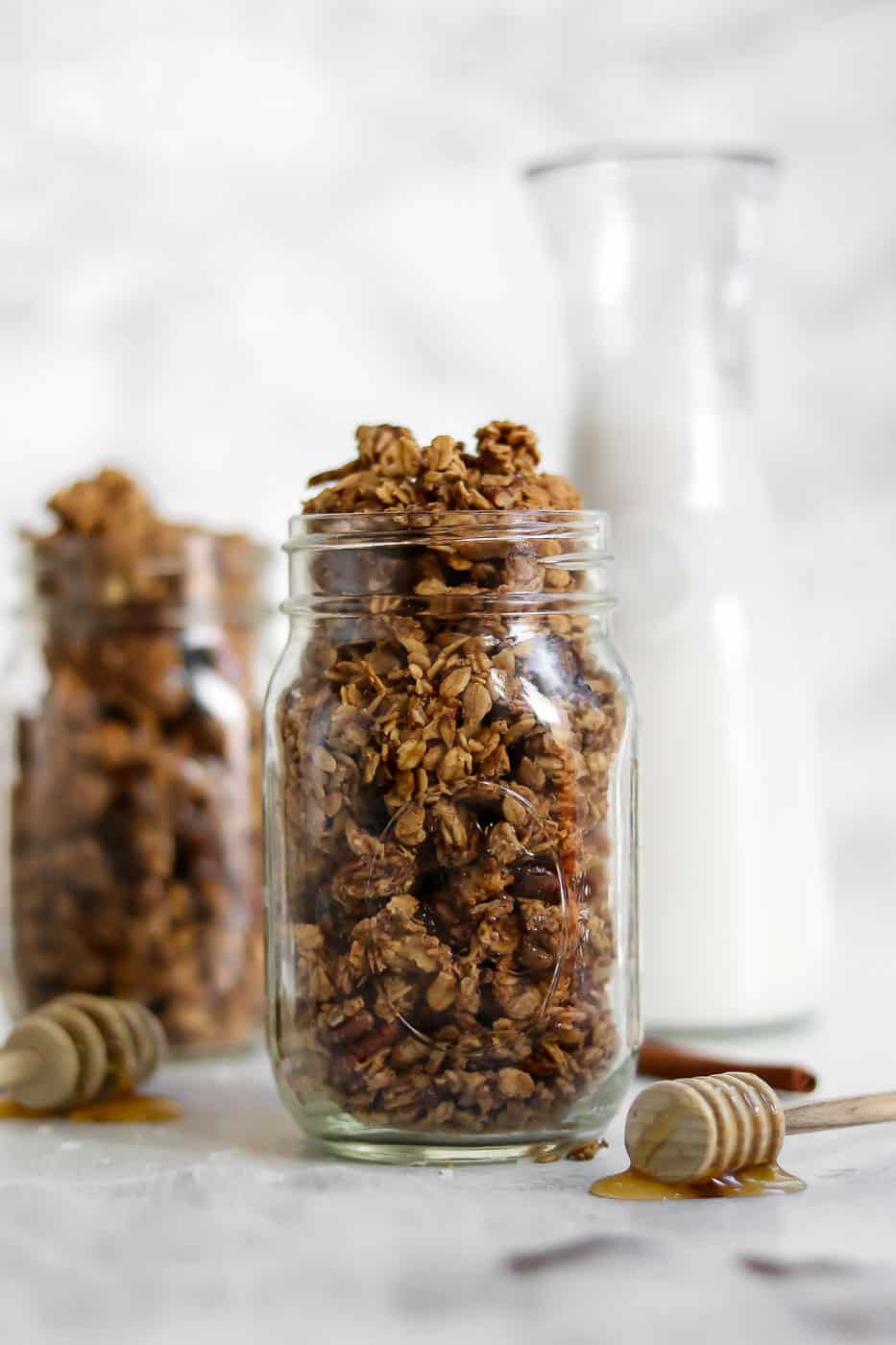 Mason jars with granola and two honey spoons. 