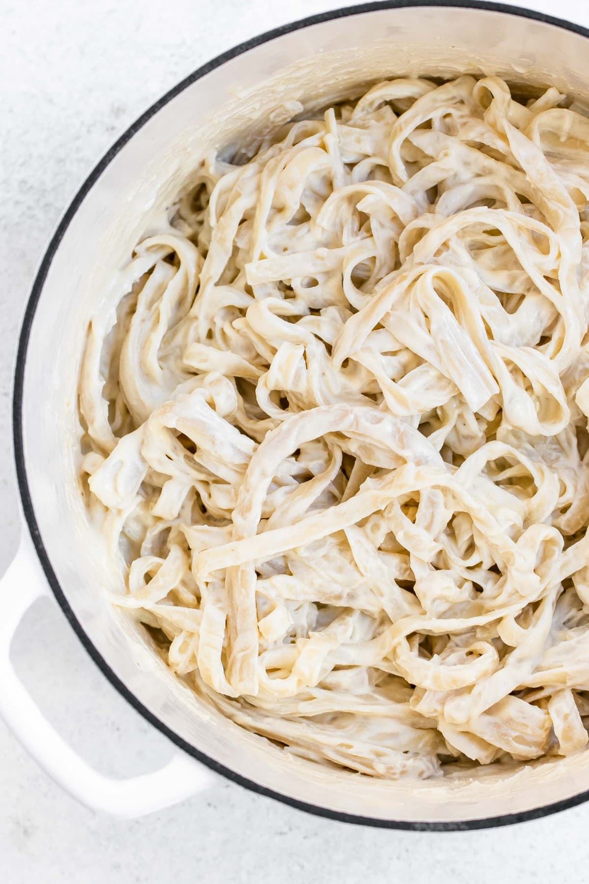 Vegan alfredo sauce recipe with pasta in a white pan.