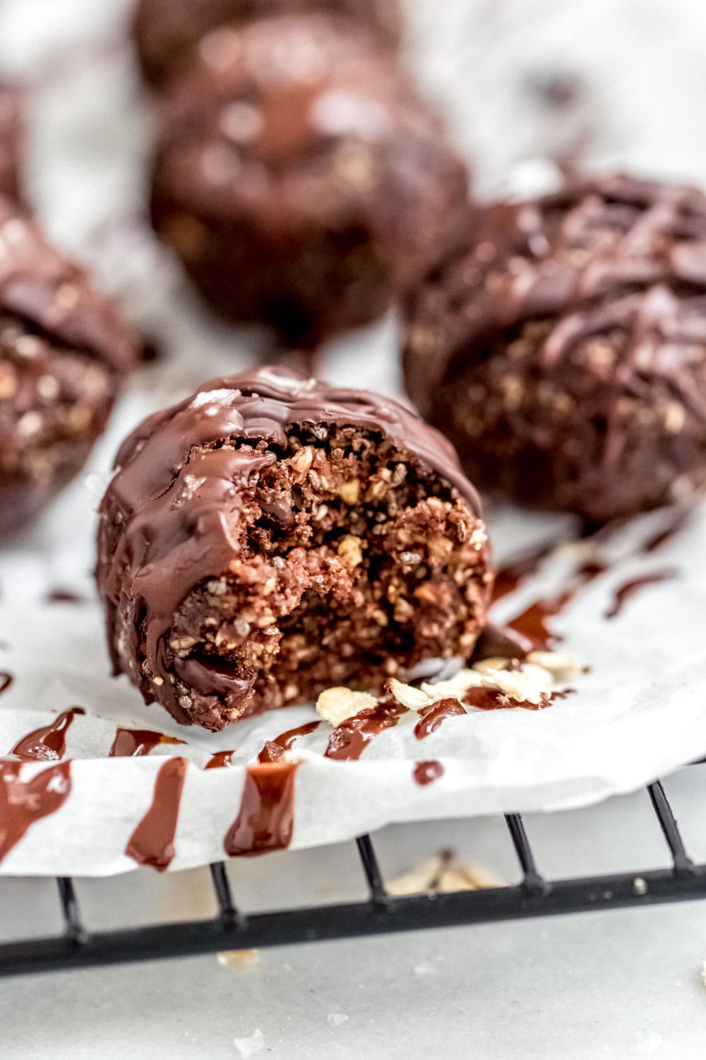 Chocolate bliss balls with chocolate drizzle on top.