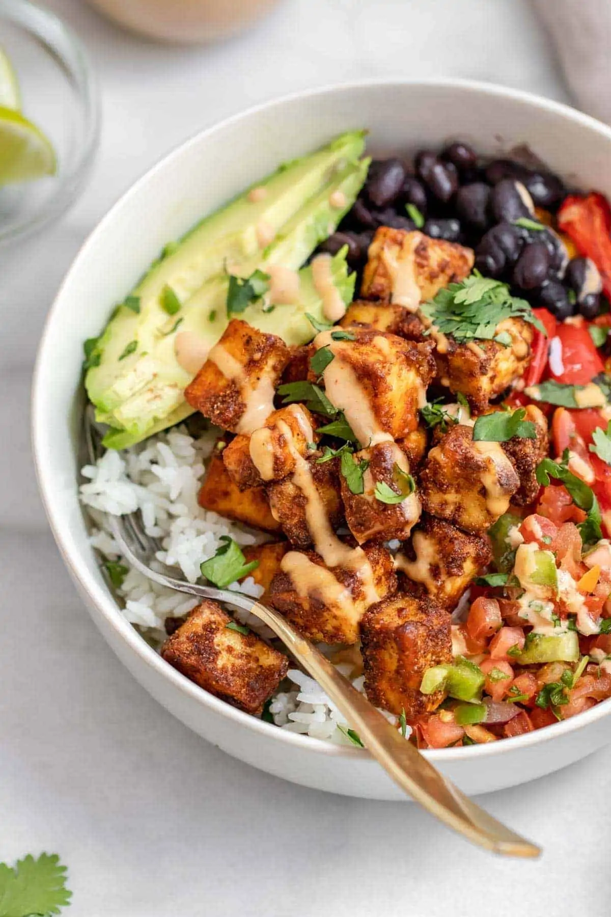 Spicy baked tofu bowl with rice, black beans and avocado. 