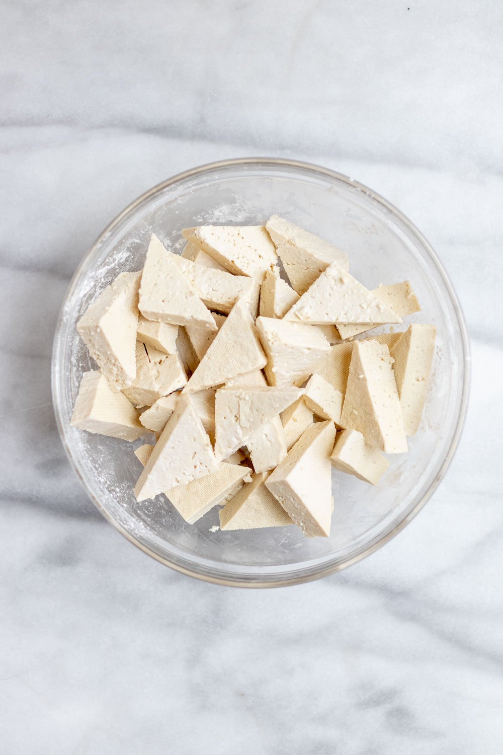 Cubed tofu in a small glass bowl. 