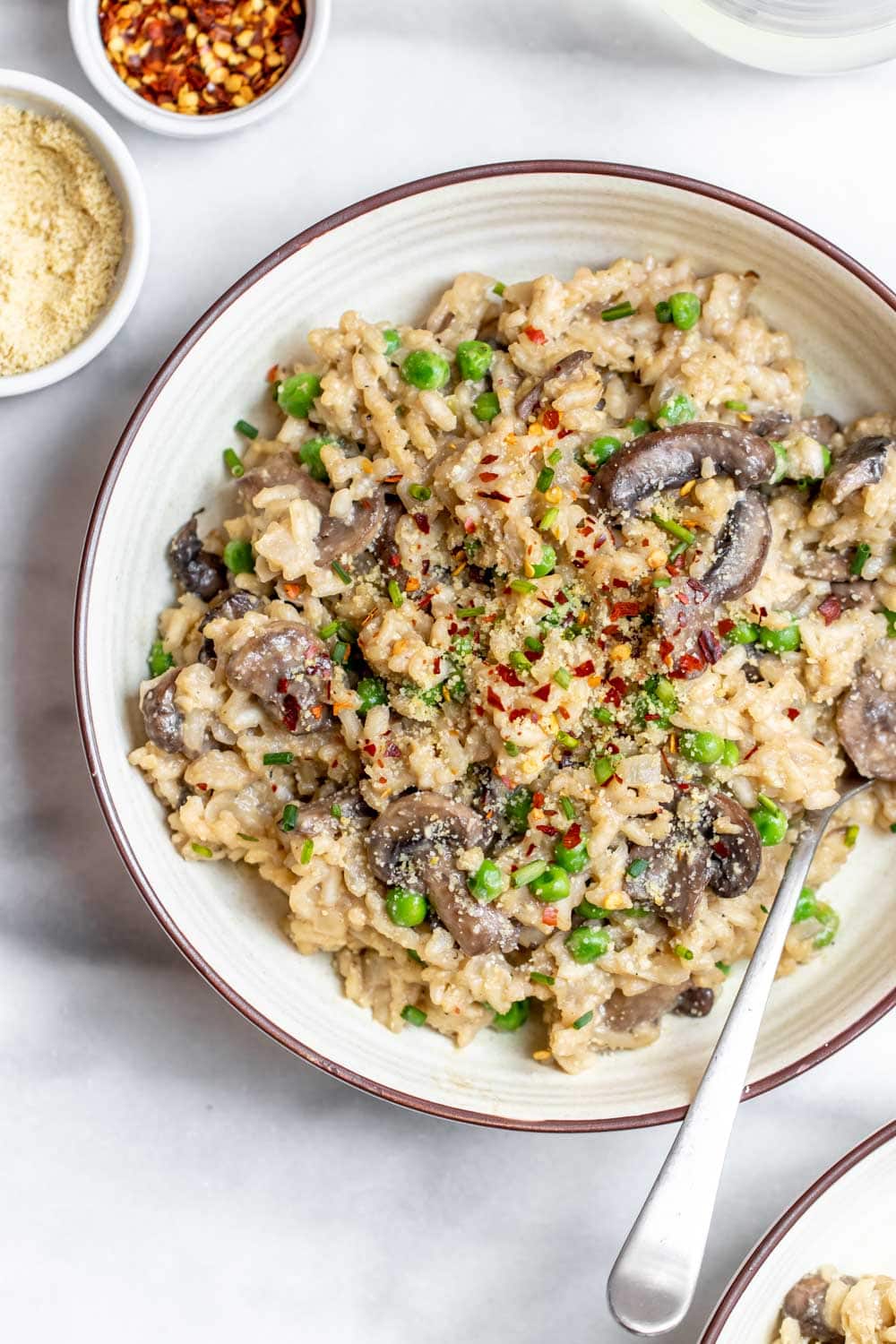 Overhead shot of risotto with mushrooms and peas.
