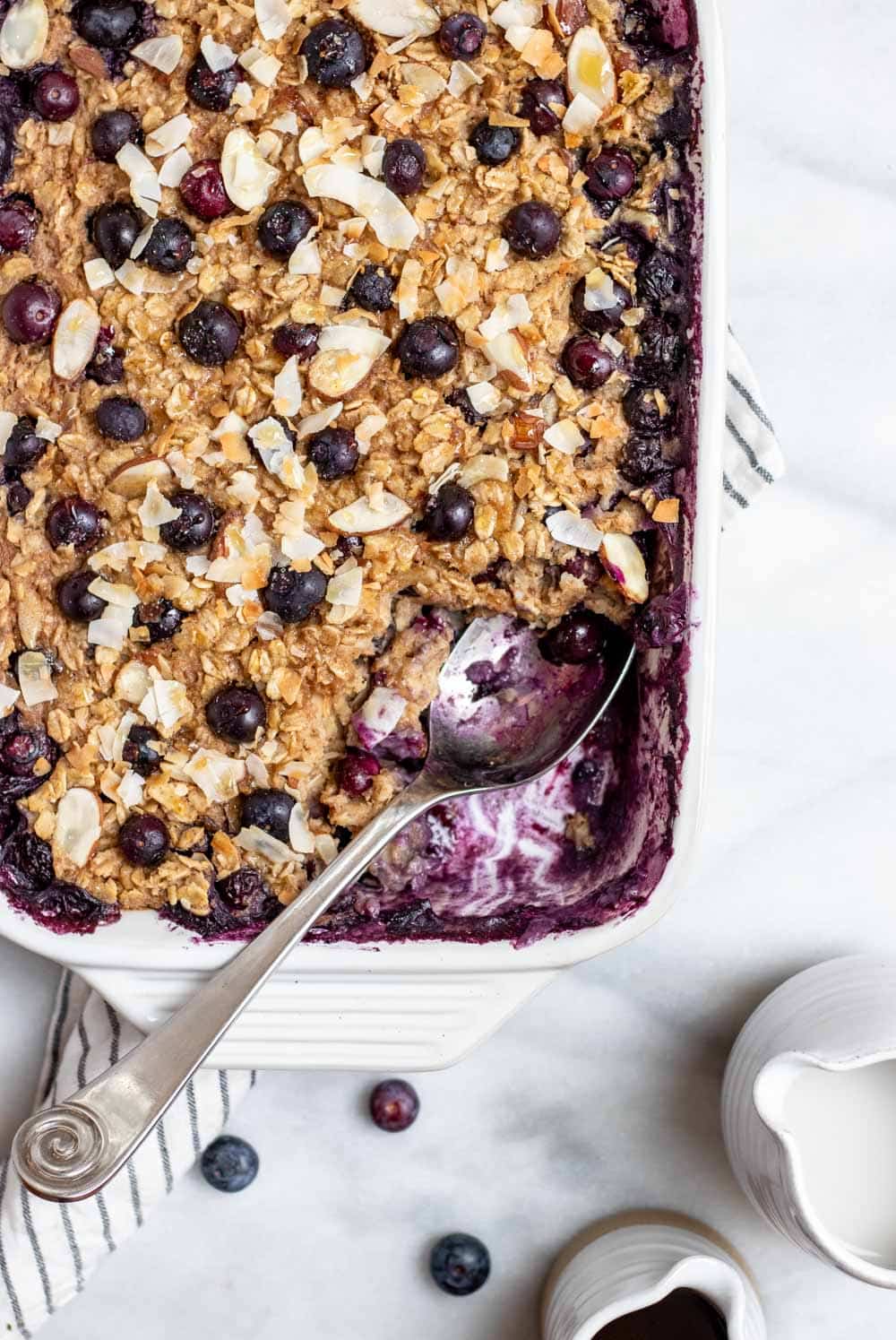 Blueberry baked oatmeal with a spoon on the side showing the berries.