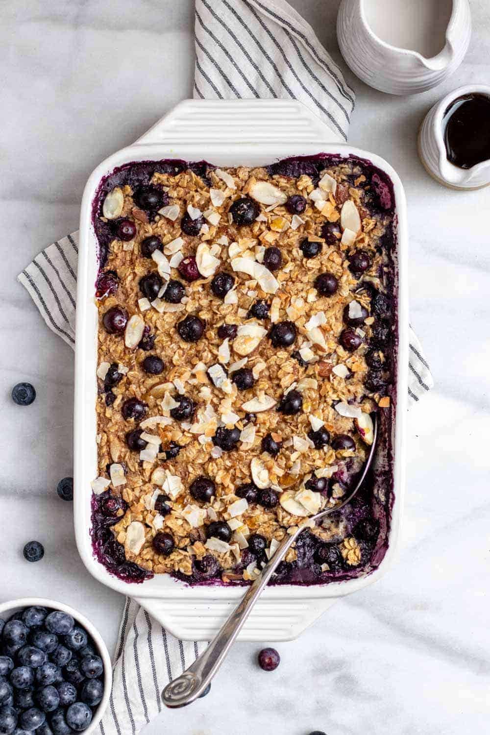 Maple cinnamon blueberry baked oatmeal in a large white baking dish.