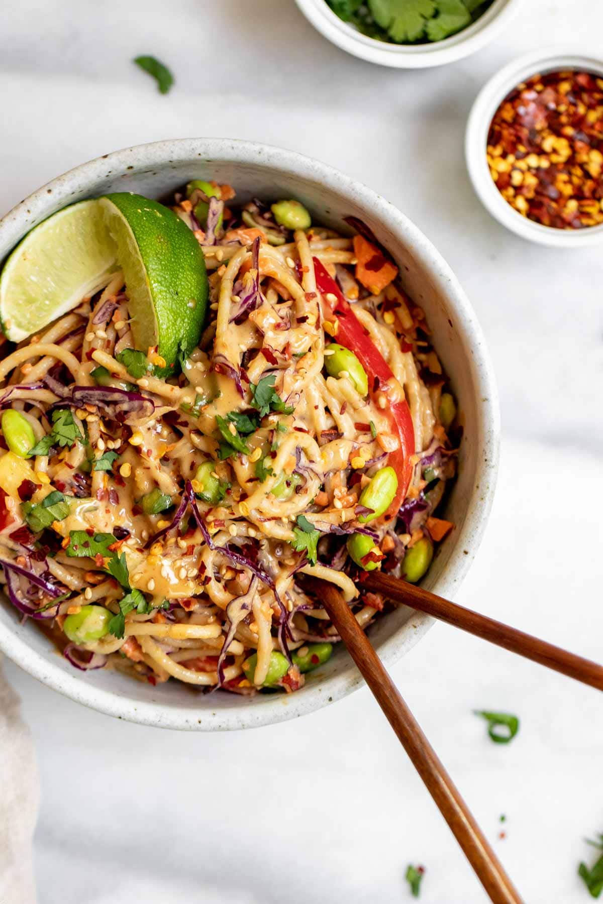 Up close image of the thai noodle salad in a bowl with chopsticks. 