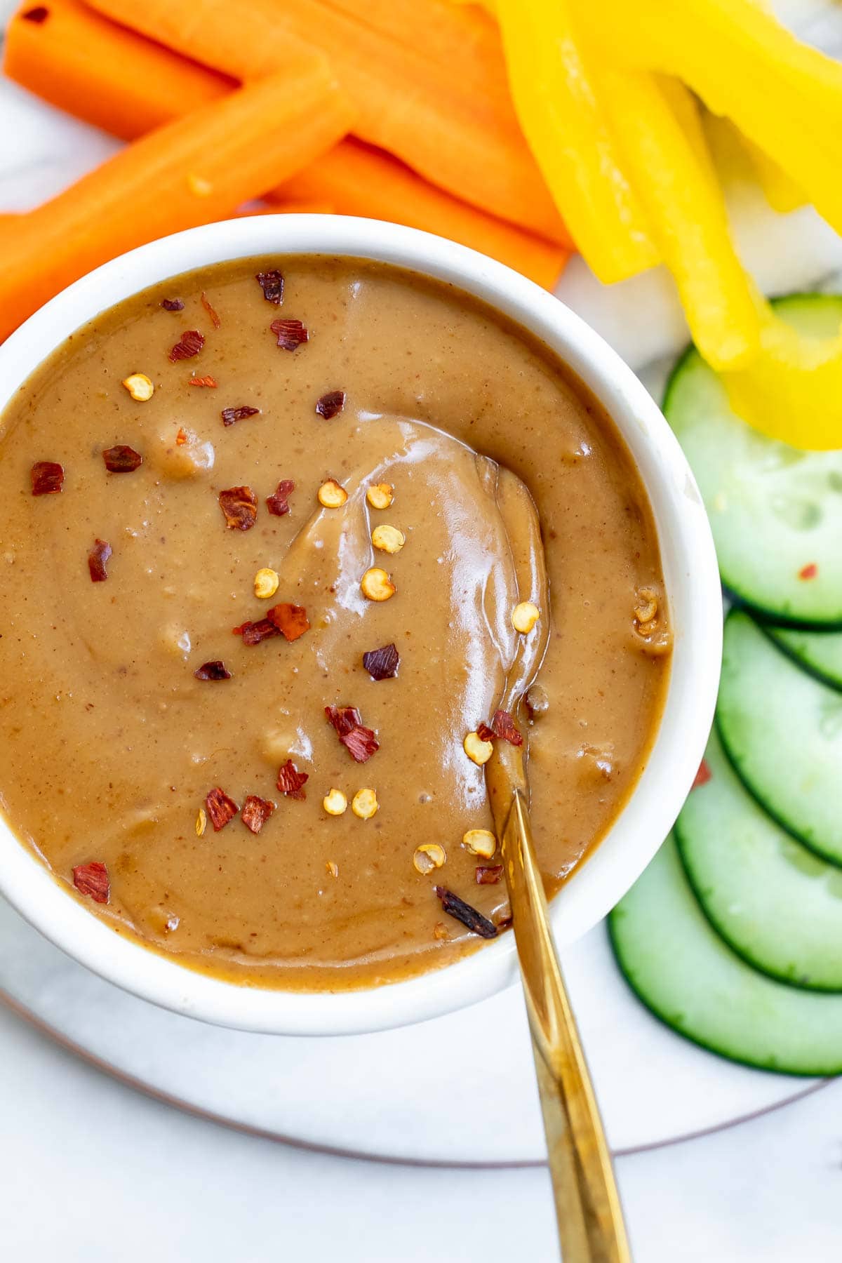 Up close image of the peanut sauce with a spoon on the side.