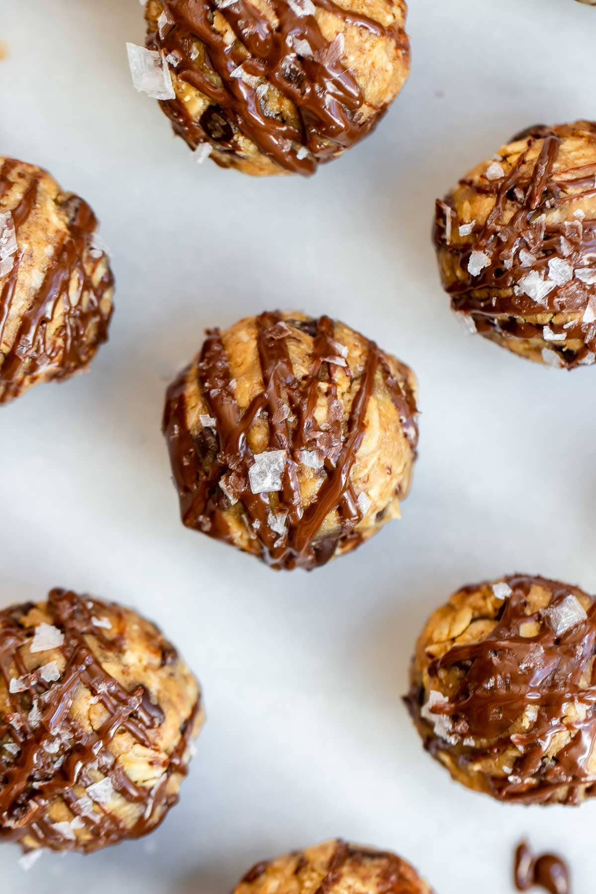 Oatmeal balls on a marble backdrop with sea salt on top.
