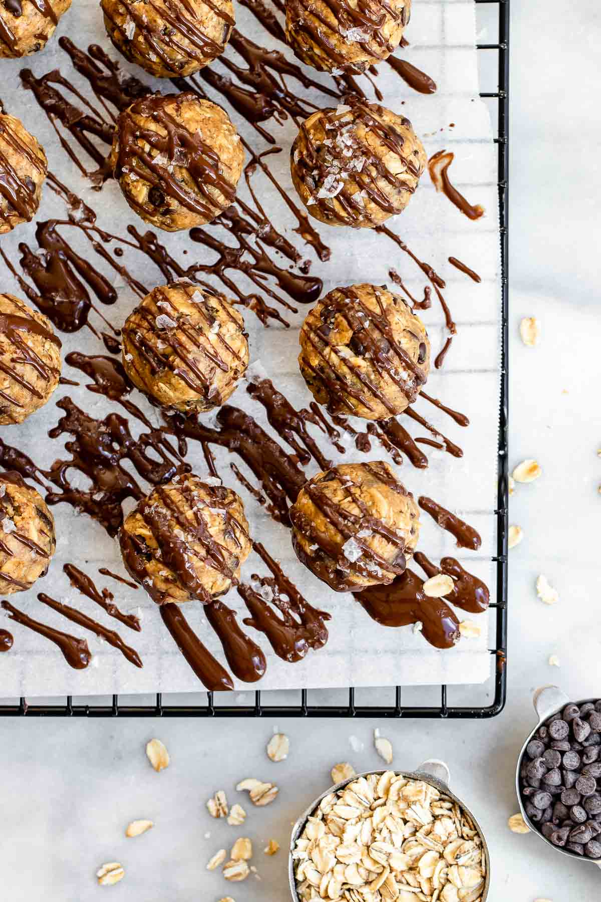 Peanut butter protein oatmeal balls on a piece of parchment paper with chocolate drizzles.