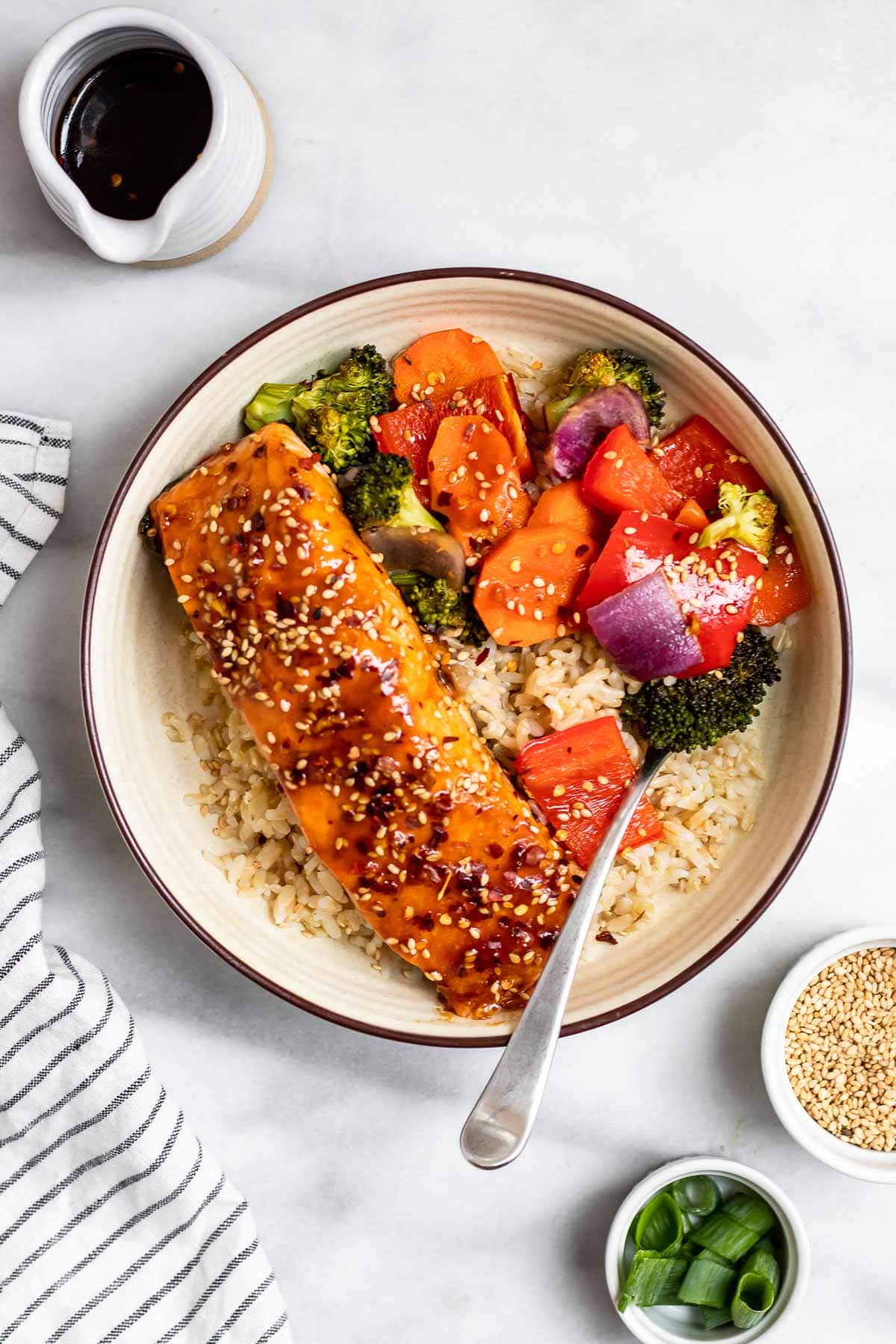 Maple soy glazed salmon on a bed of rice with roasted vegetables.