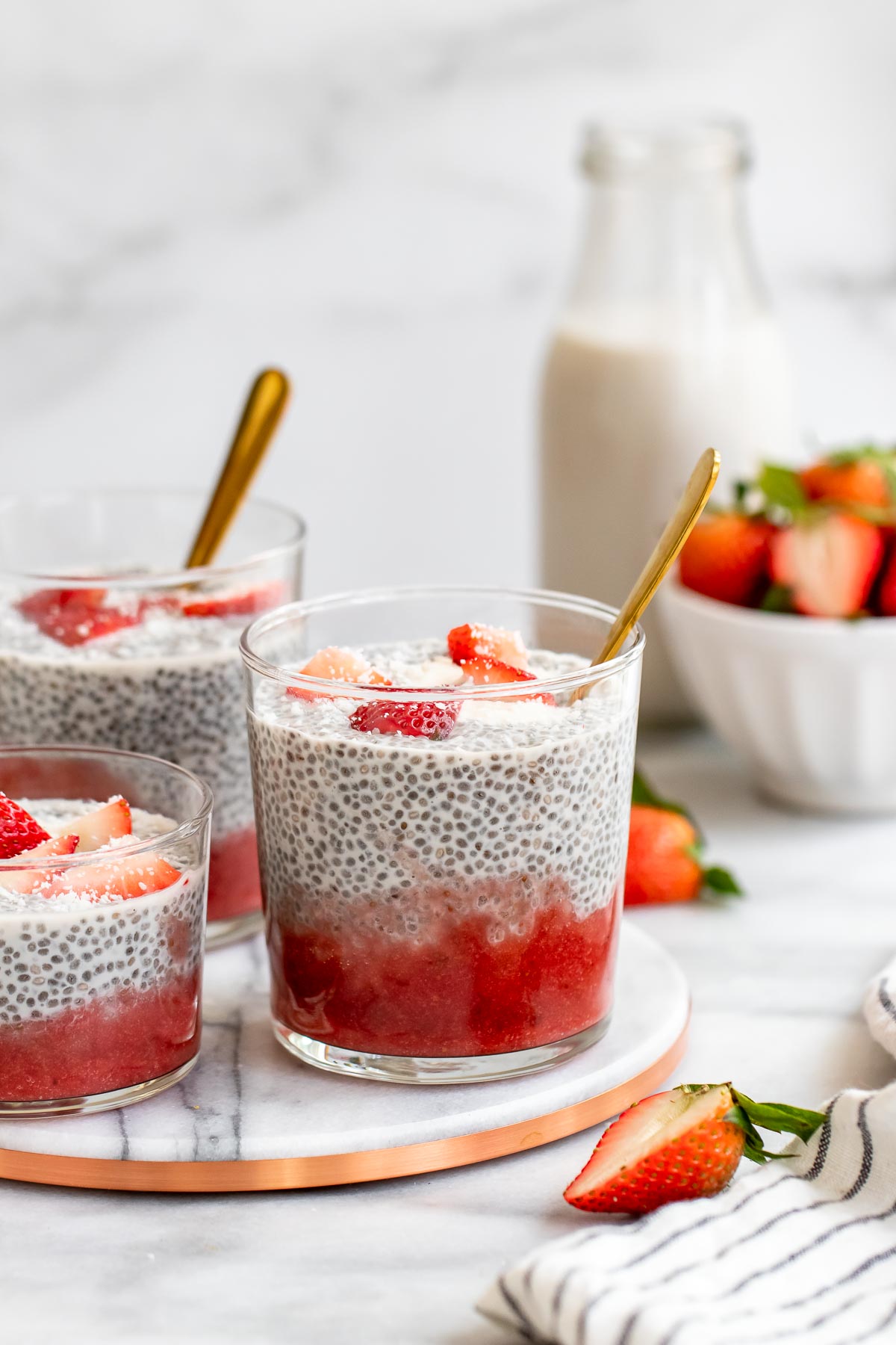 Three jars with the coconut chia pudding and strawberry puree.