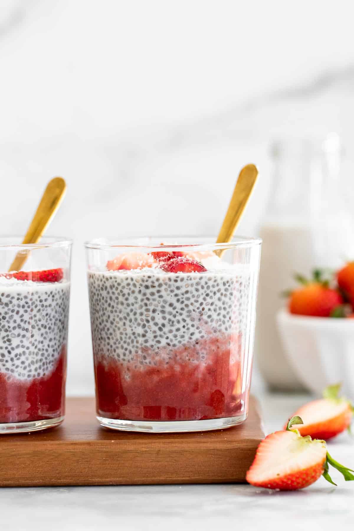 Two jars of the chia pudding on a wooden board.