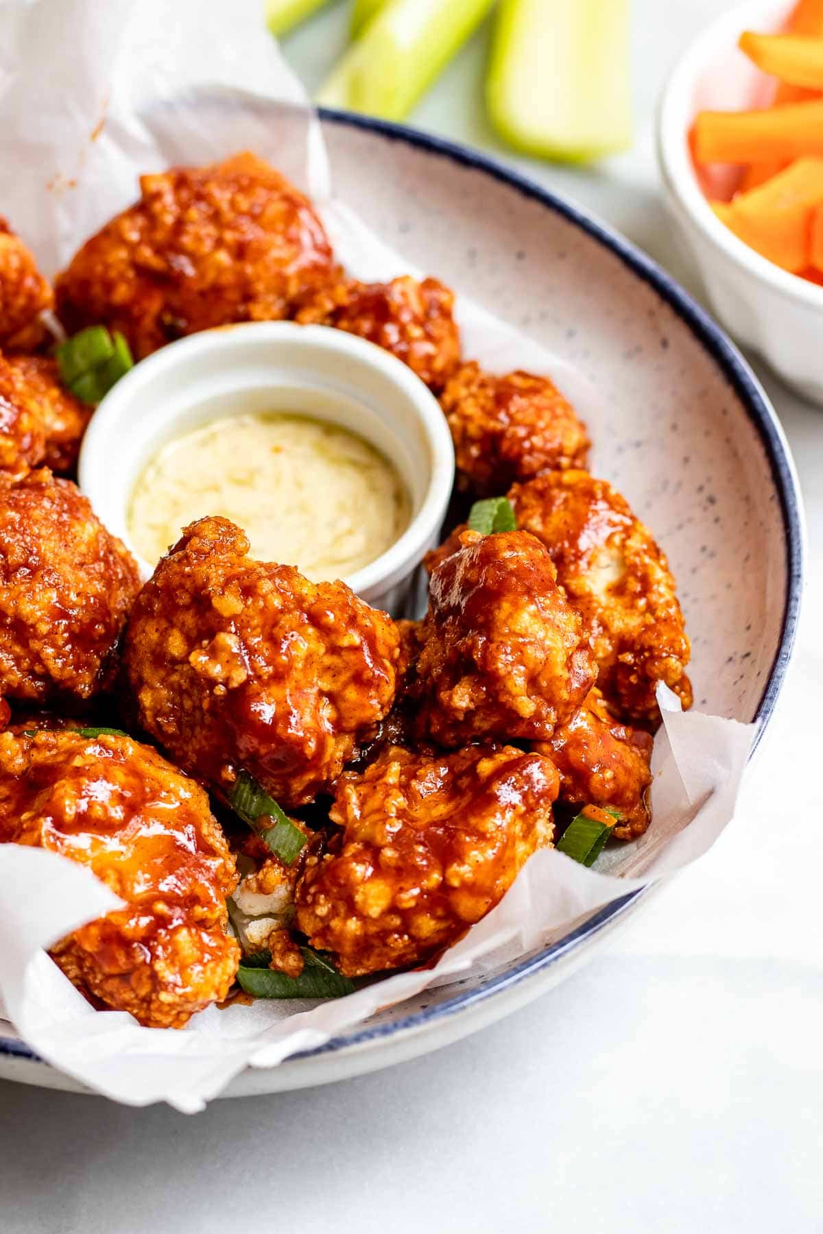 Up close image of bbq cauliflower with ranch dip on the side.