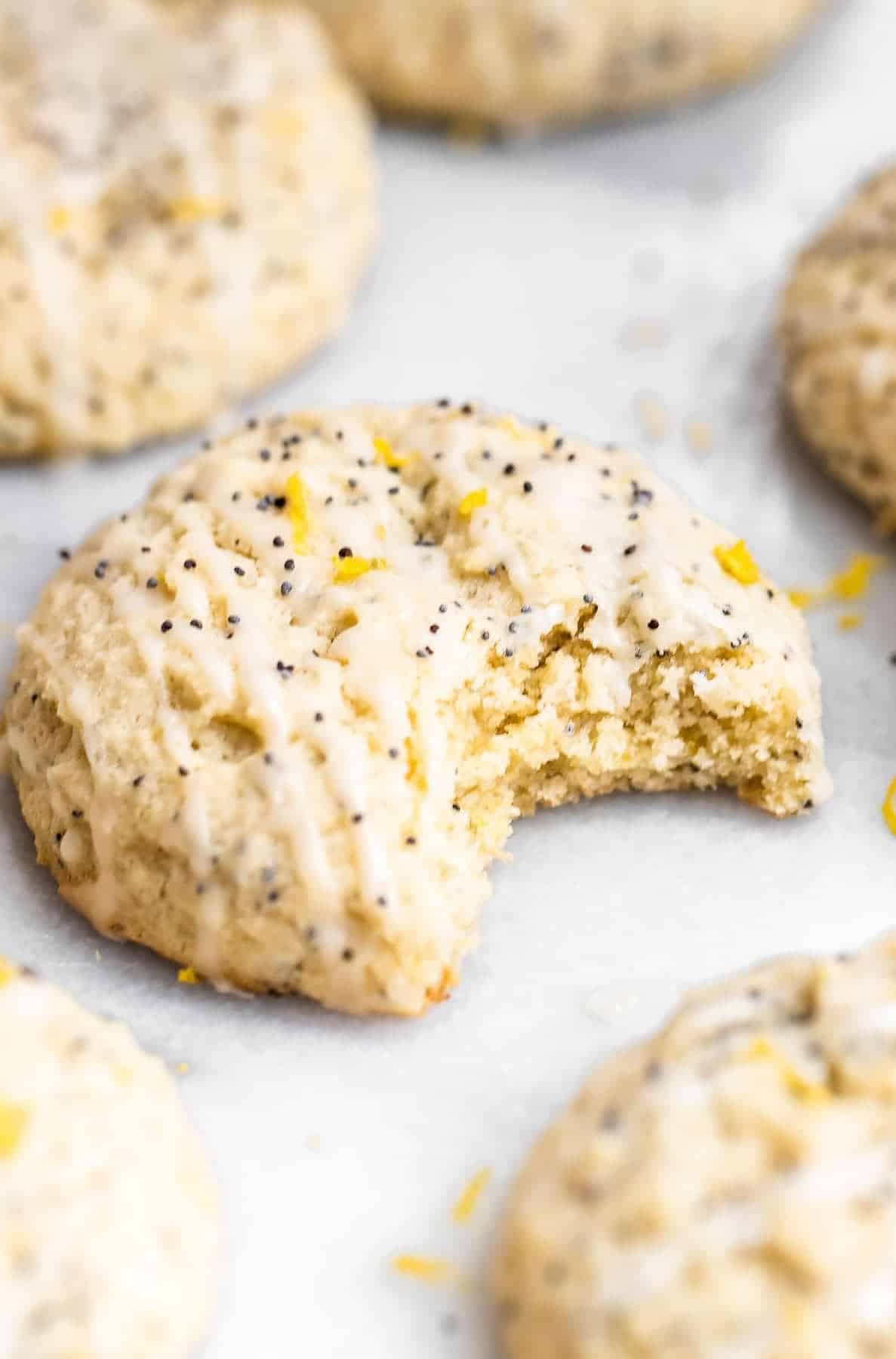 Up close image of lemon cookies with one bite taken out. 