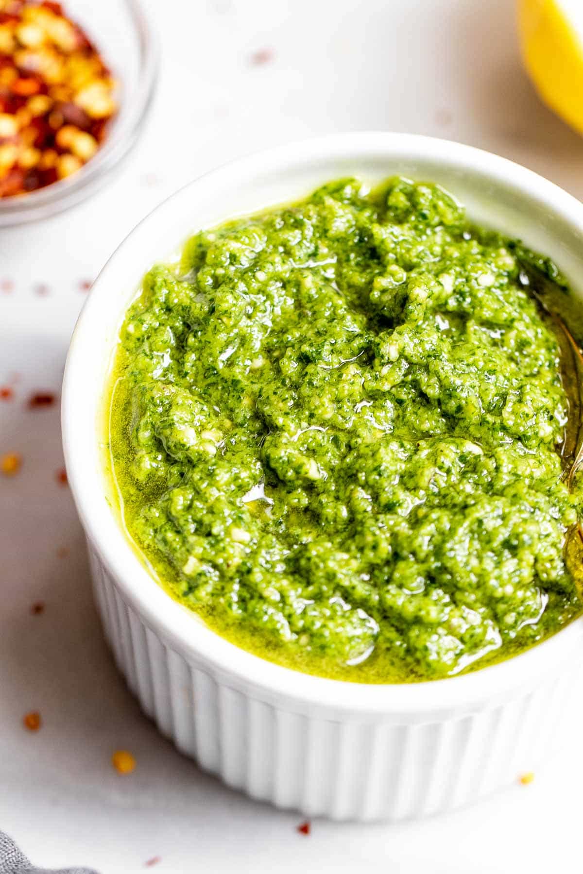 Up close image of pesto in a small white bowl.