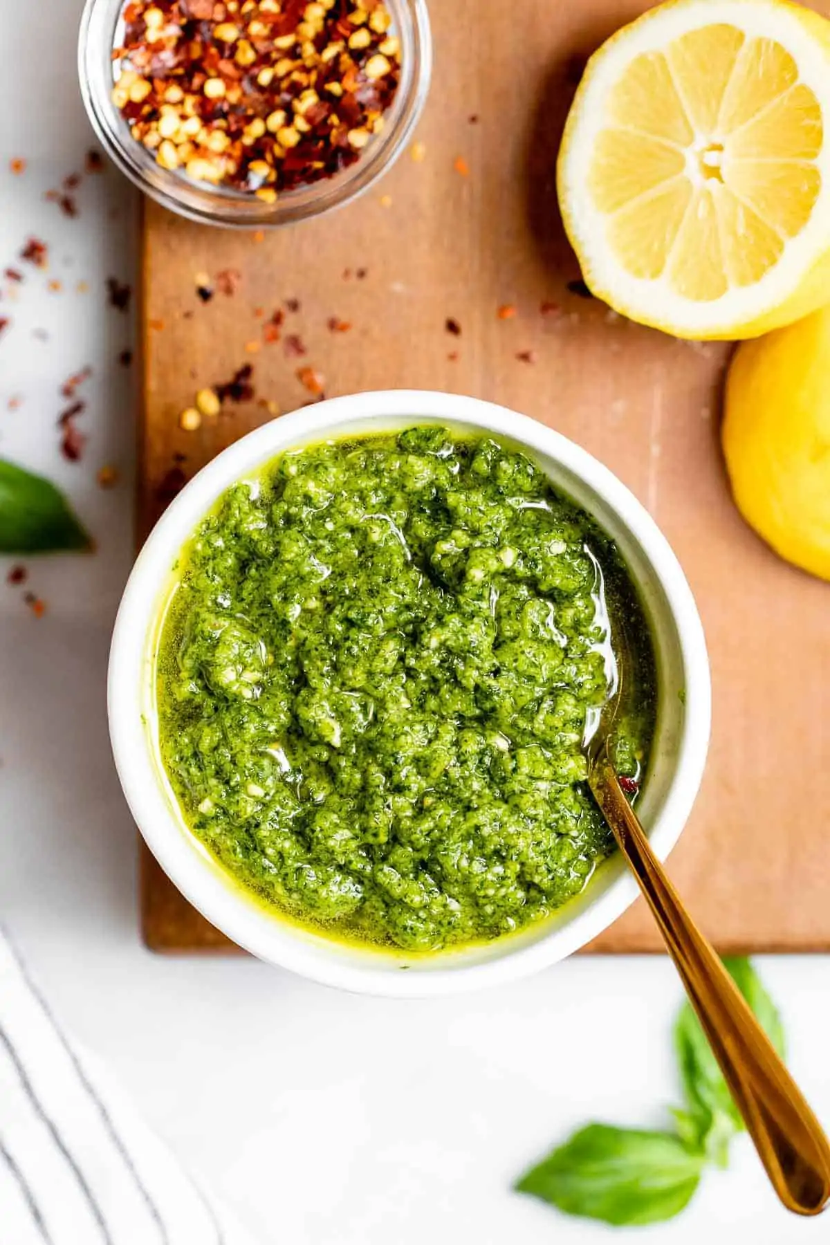 Vegan dairy free pesto in a bowl with a gold spoon on the side.