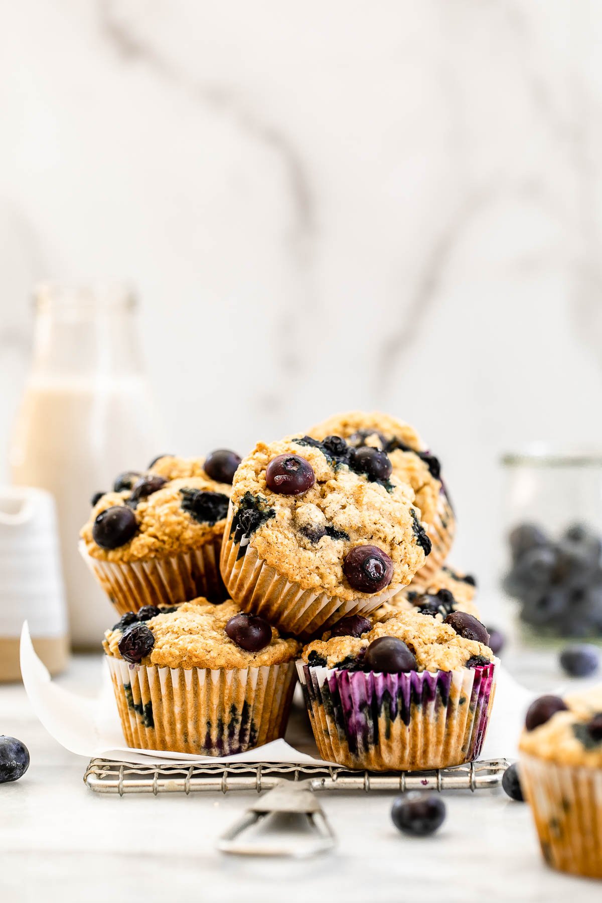 Vegan oatmeal muffins stacked on each other with milk in the background. 