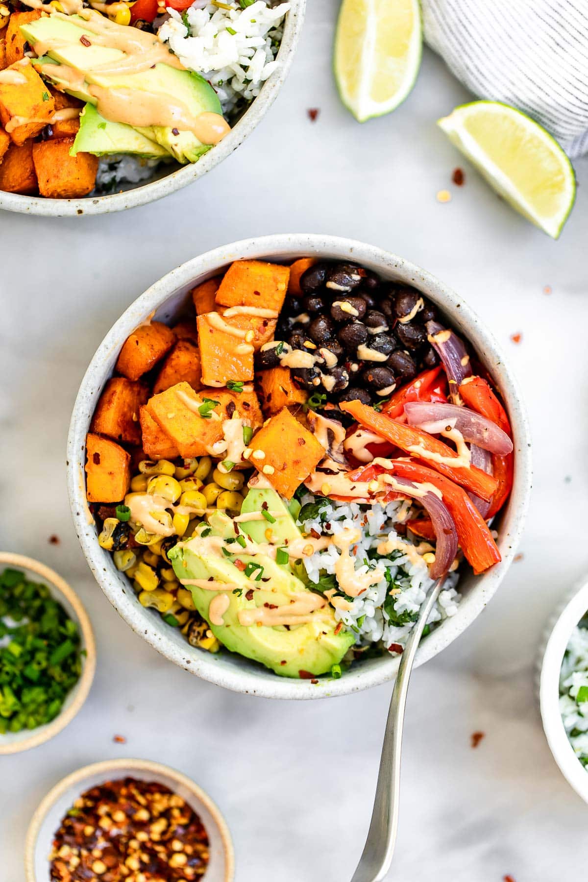 Two bowls with the roasted veggies, sweet potato and black beans.