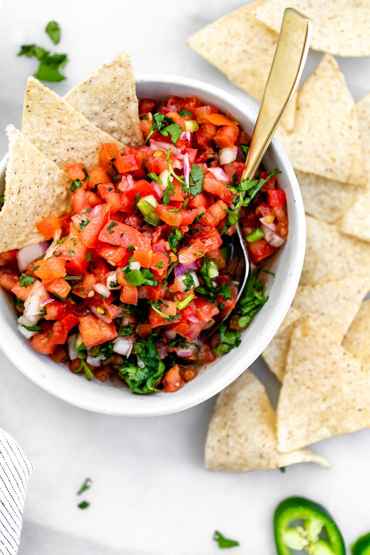 Overhead shot of the pico de gallo with a spoon on the side with chips.
