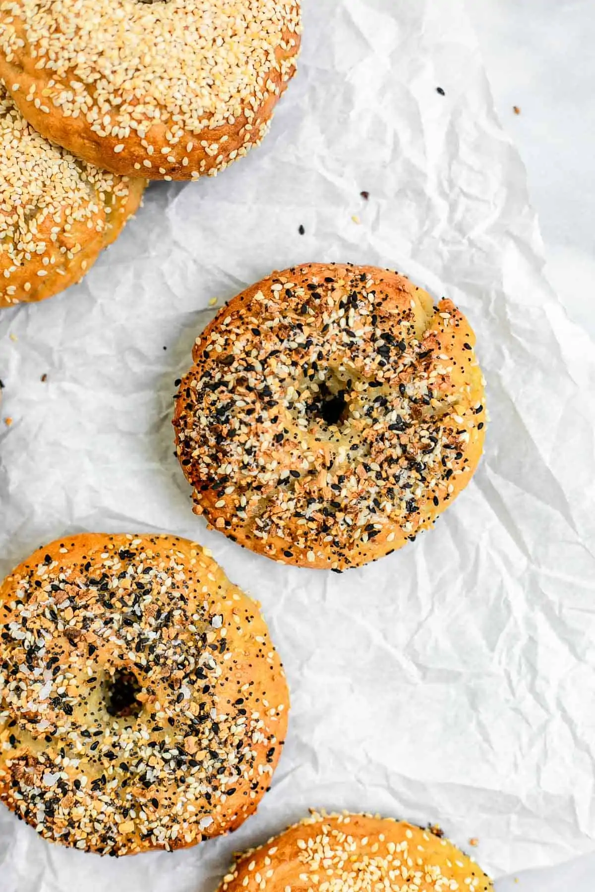 Gluten free bagels on a piece of parchment paper. 