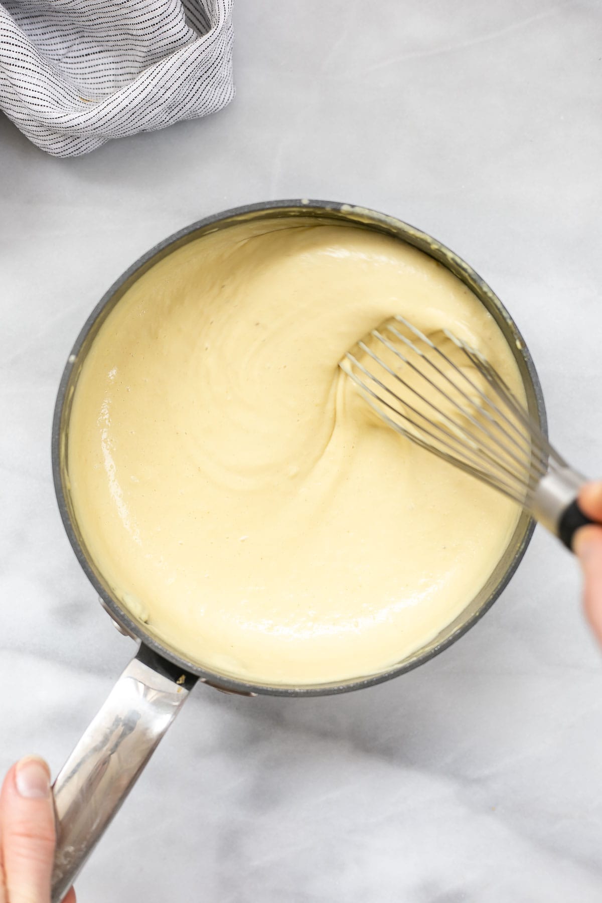 Whisking the cheese sauce.