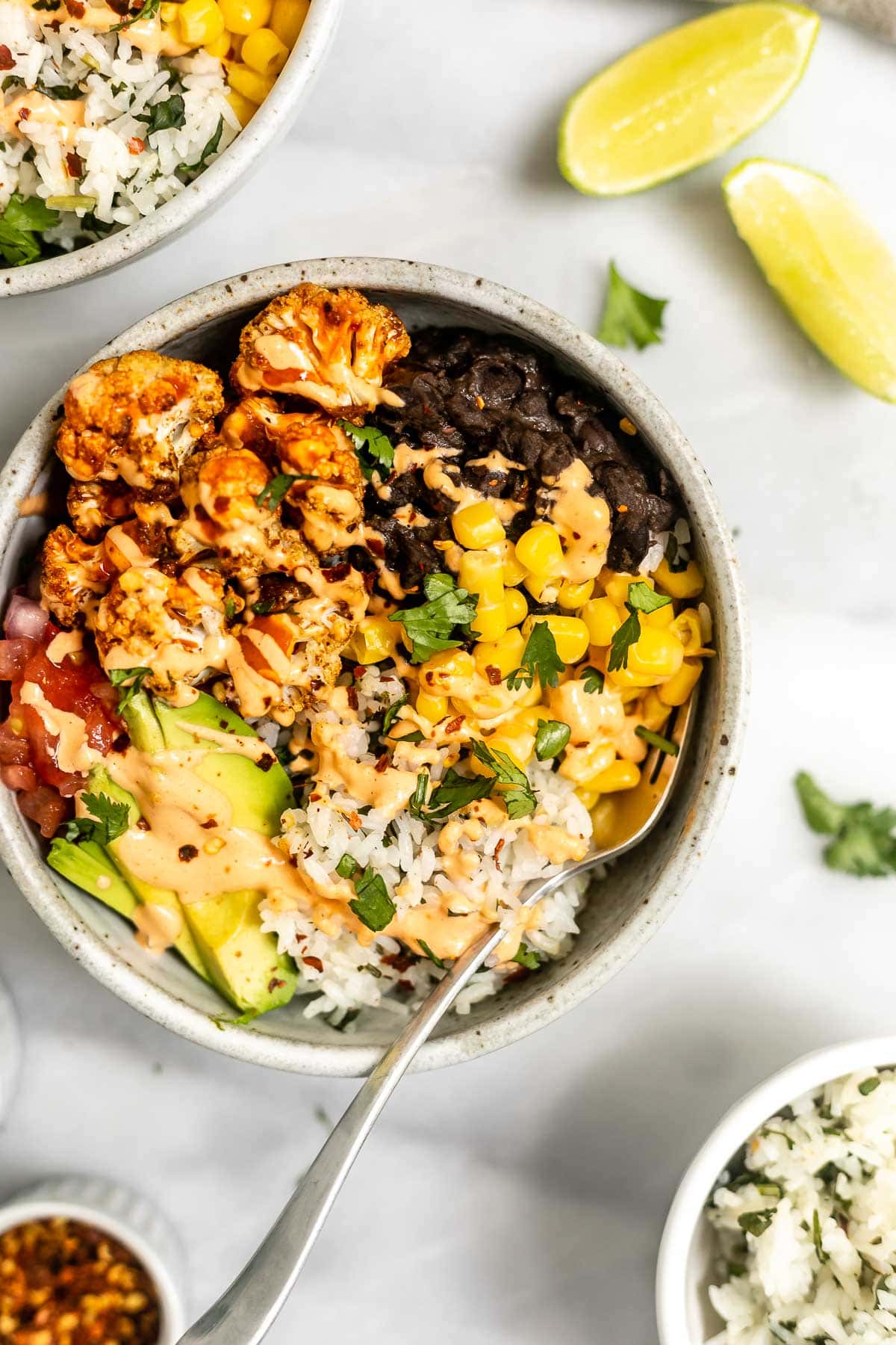 Vegan cauliflower bowl with lime wedges on the side.