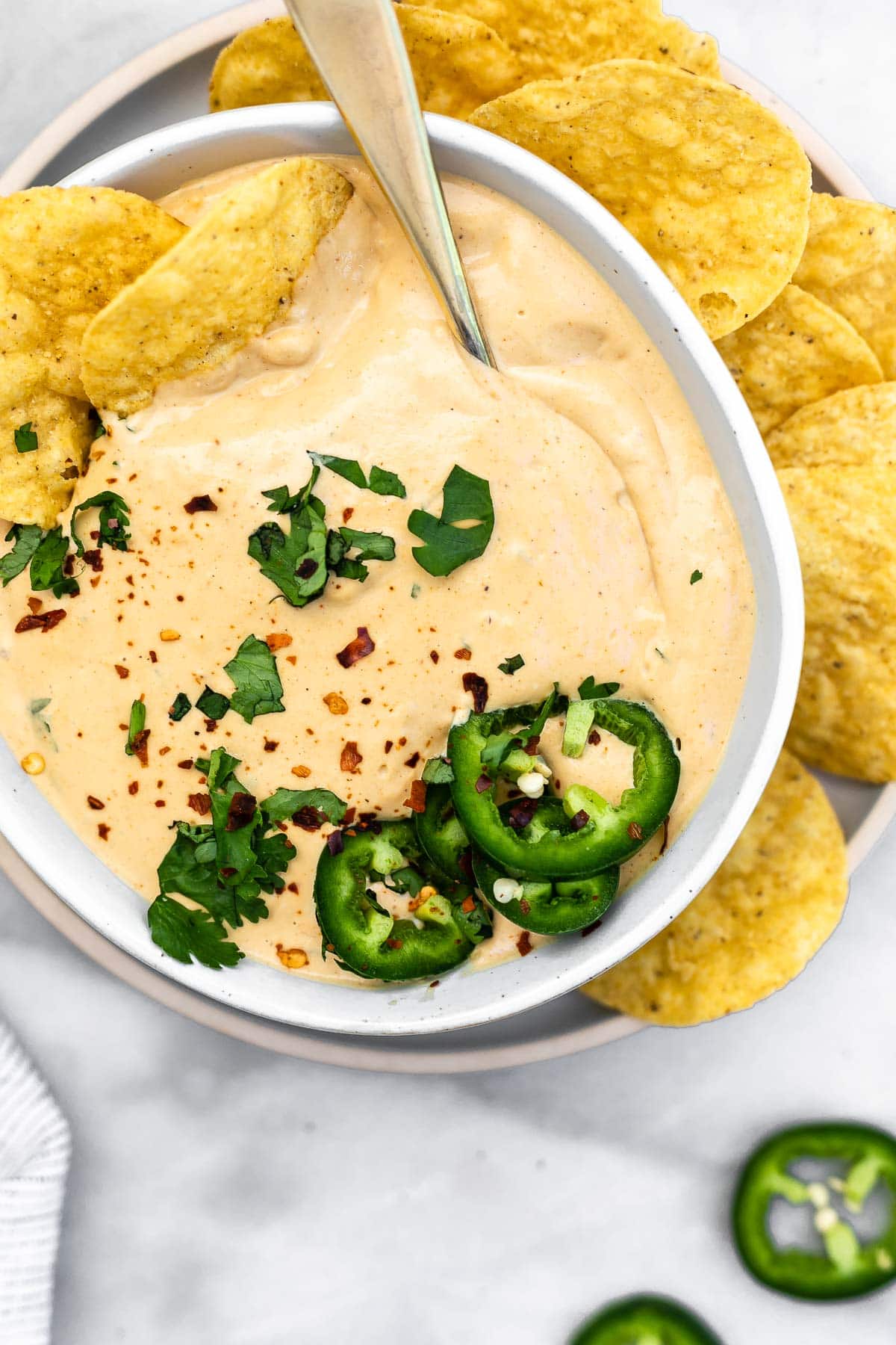 Vegan cashew queso in a small bowl with chips on the side.