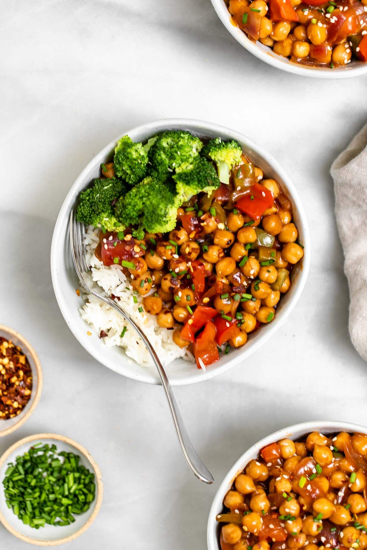 Chickpea stir fry with broccoli and rice in three bowls.