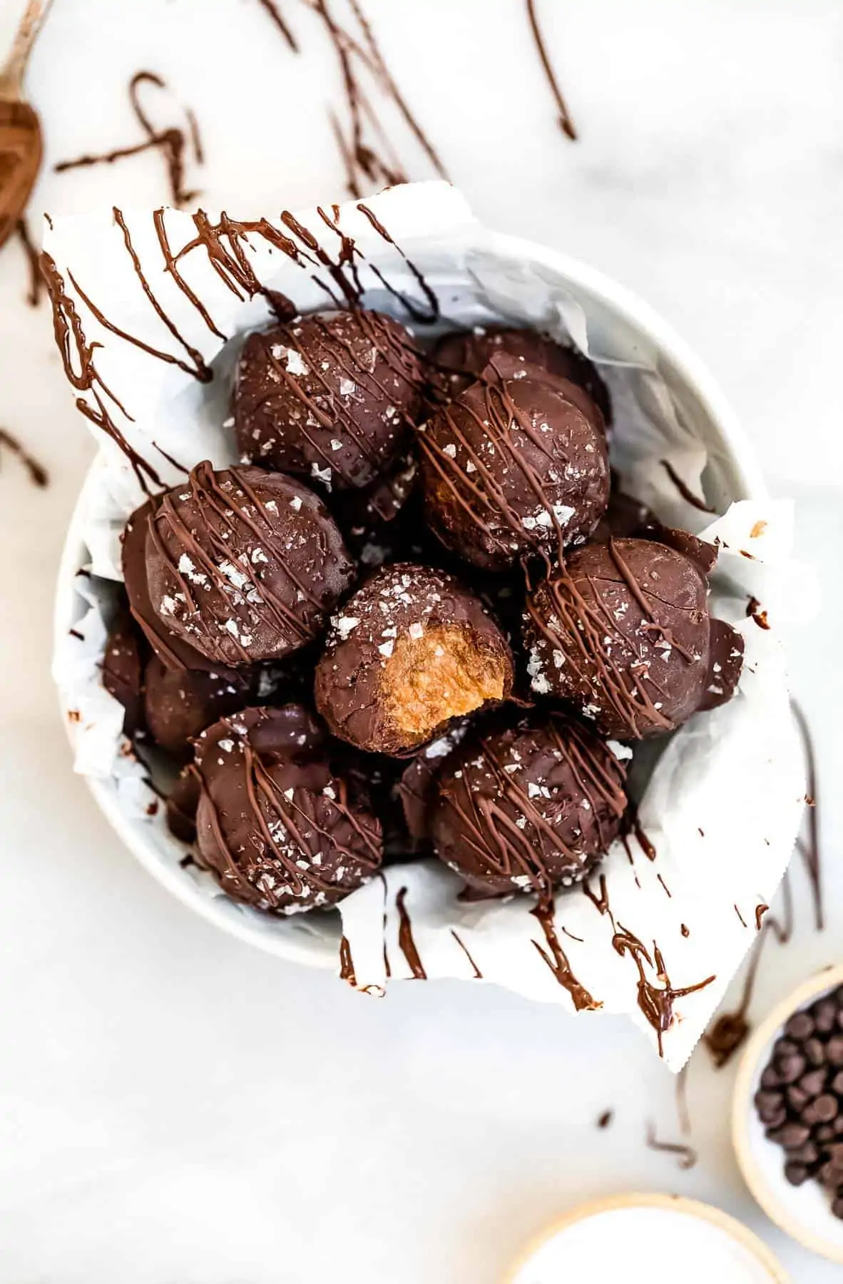 Truffles in a bowl with chocolate drizzled on top.