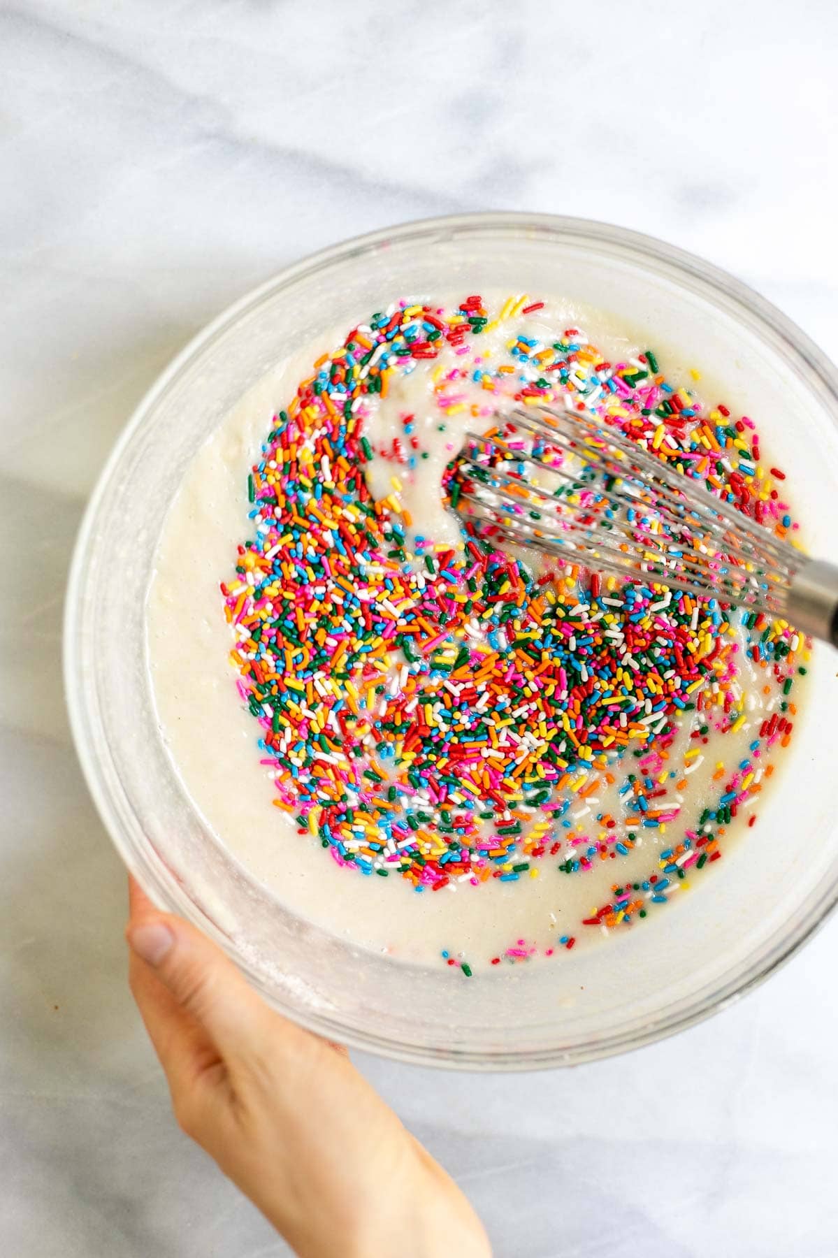 Mixing the sprinkles in the batter.