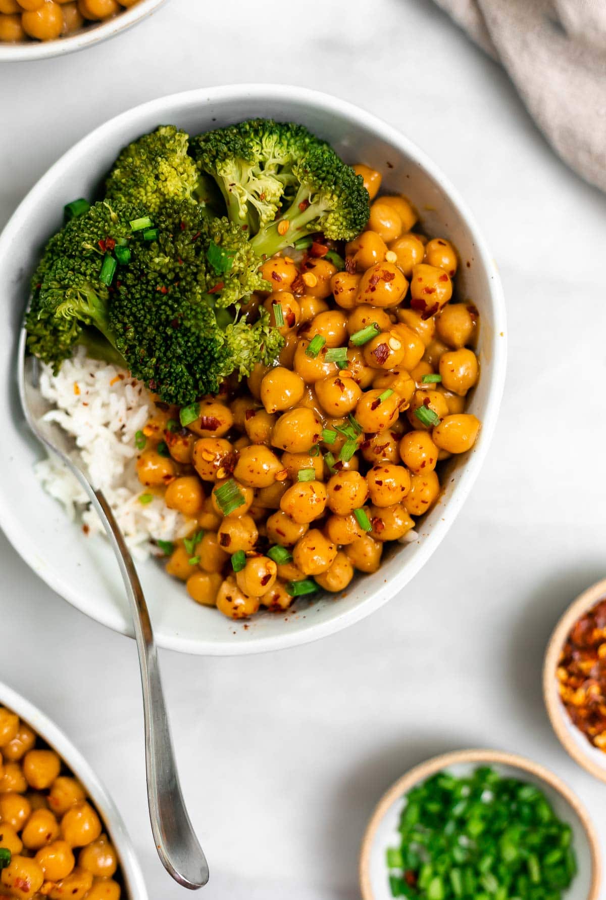 Orange chickpeas in a bowl with broccoli and rice.