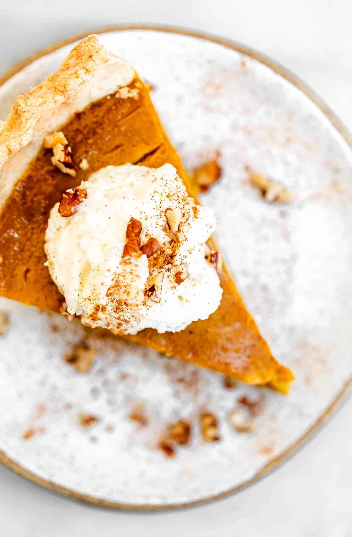Overhead shot of vegan pumpkin pie with whipped cream on top.