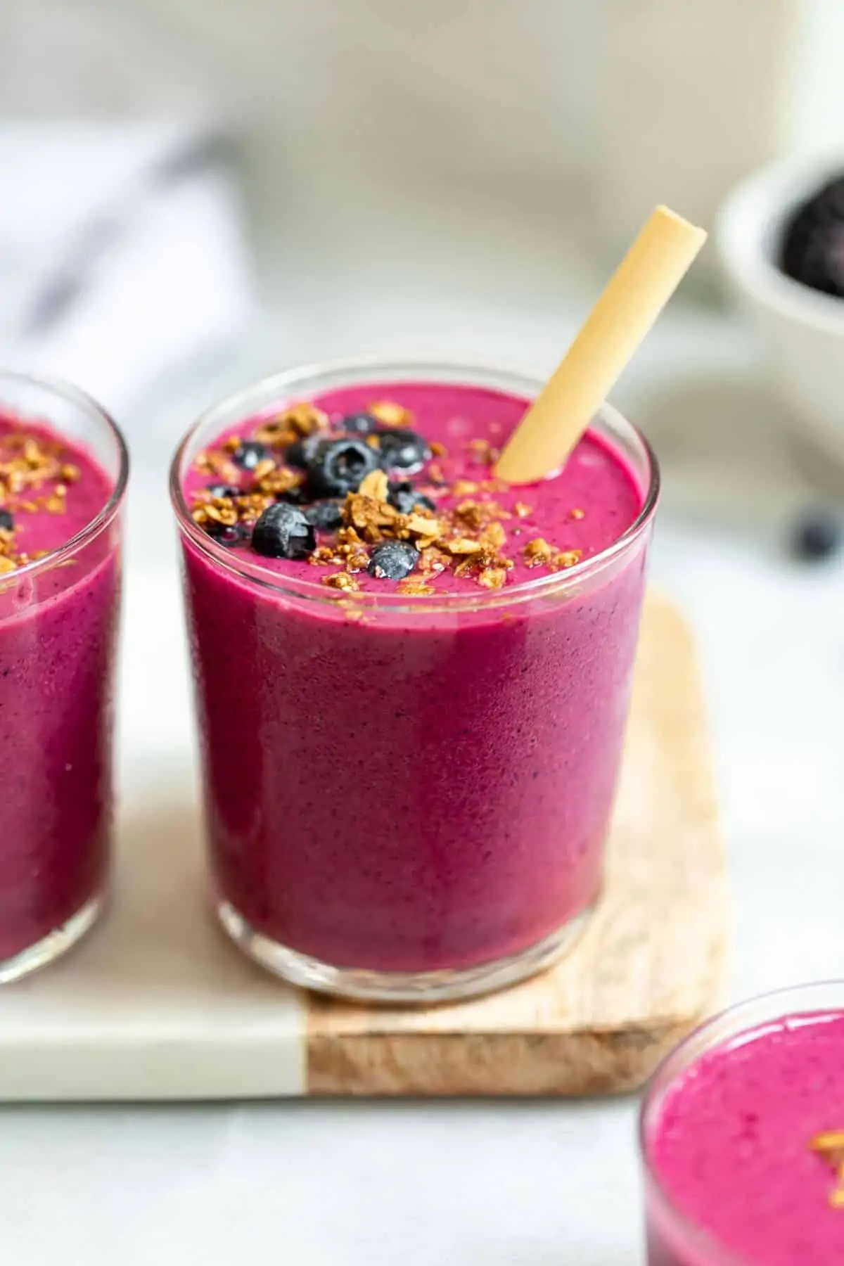 Beet smoothie in glass with blueberries on top.