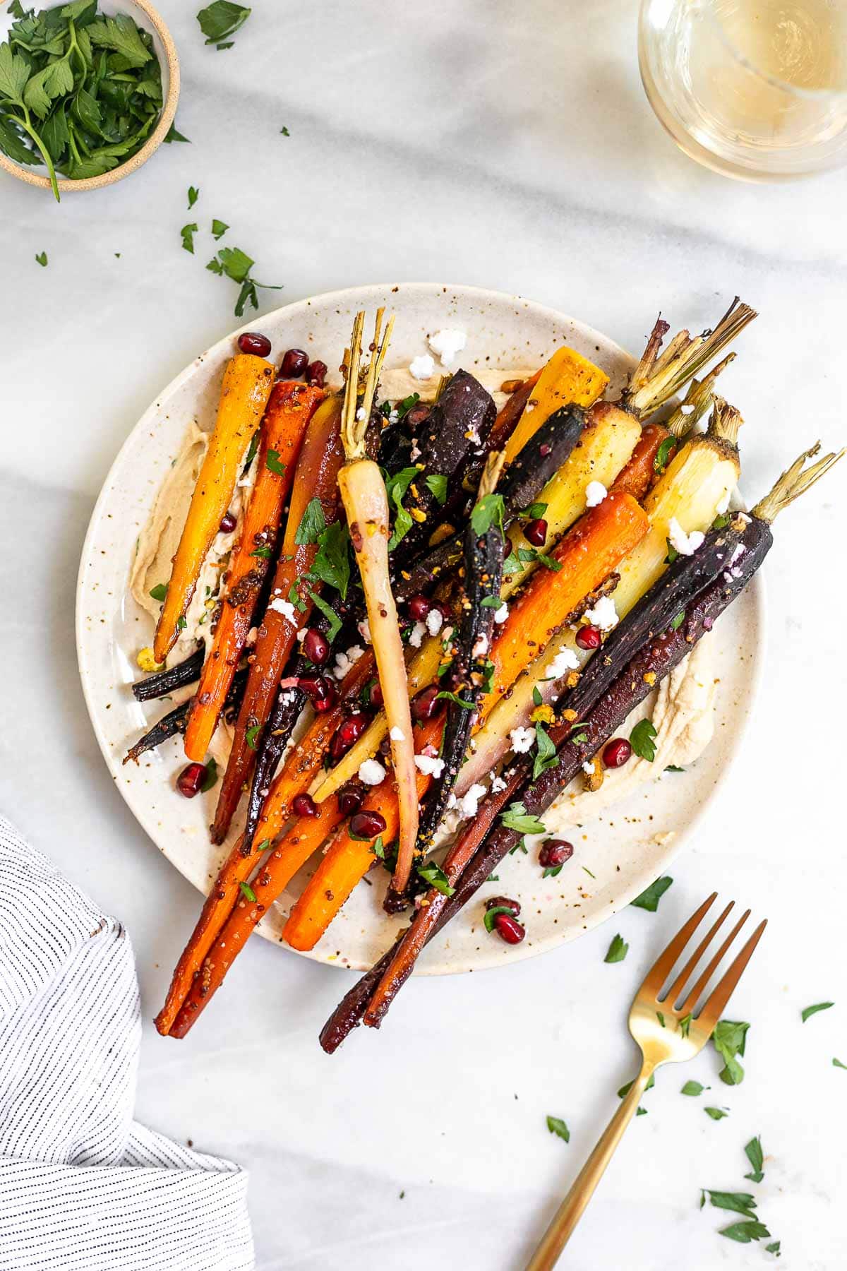 Roasted veggies on a plate with pomegranate on top.