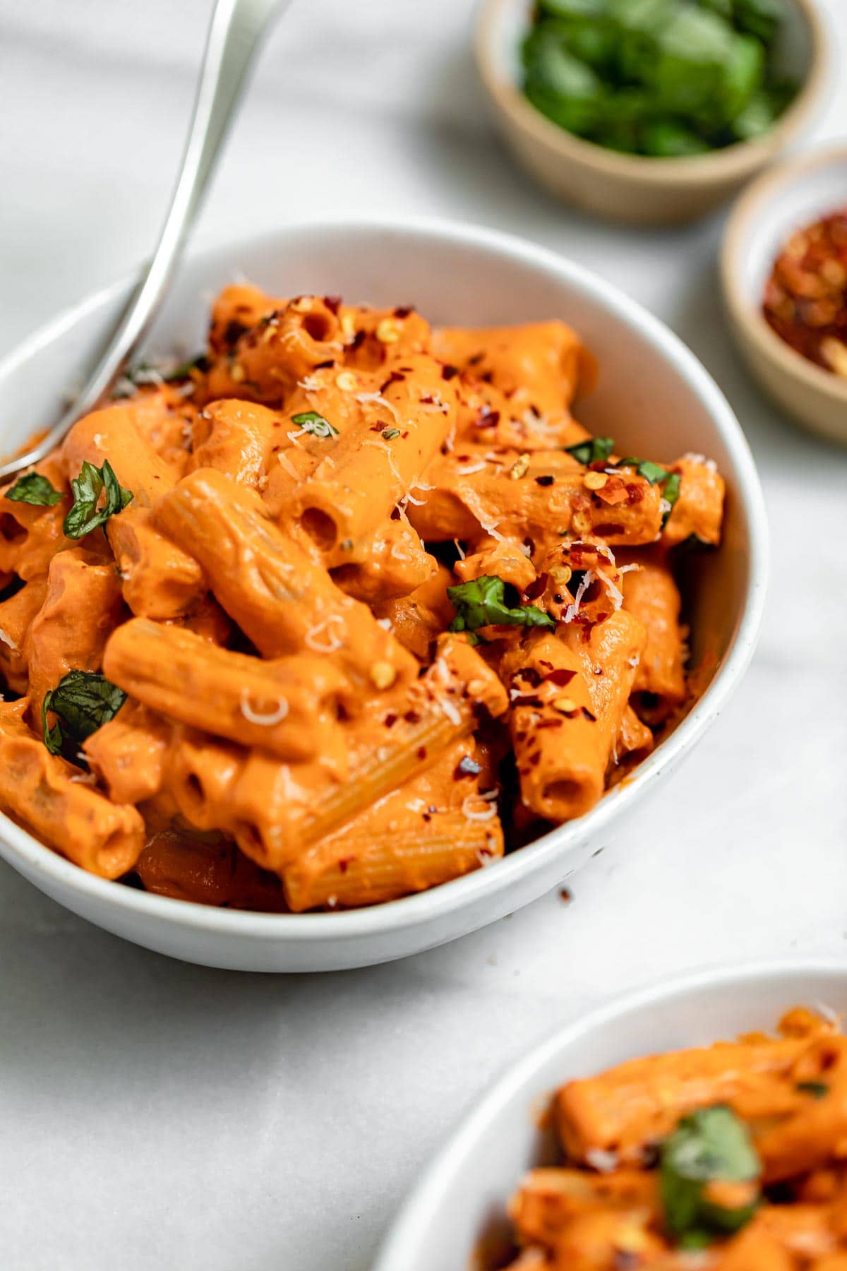 Roasted red pepper pasta with basil on top.