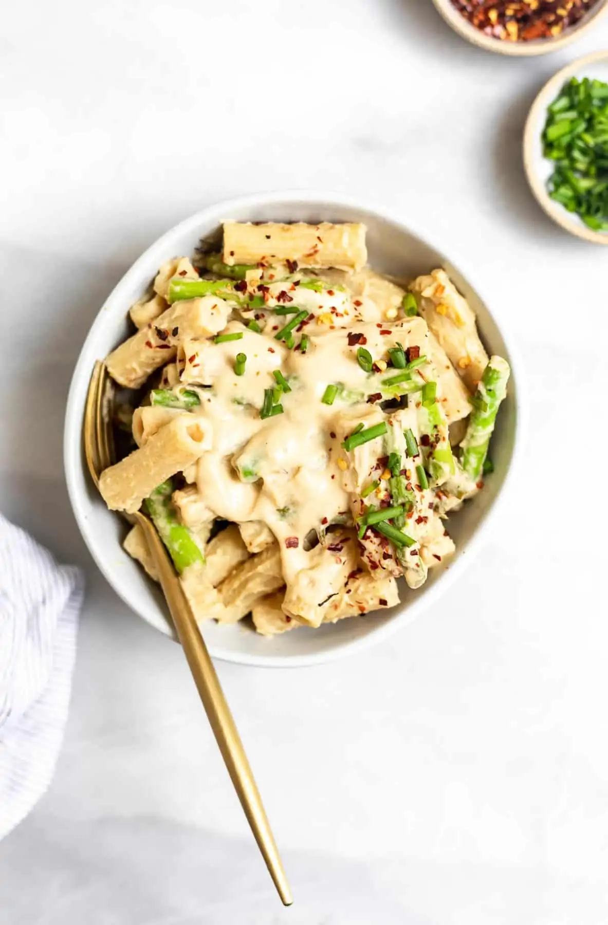 Vegan white bean pasta with asparagus in a small bowl. 