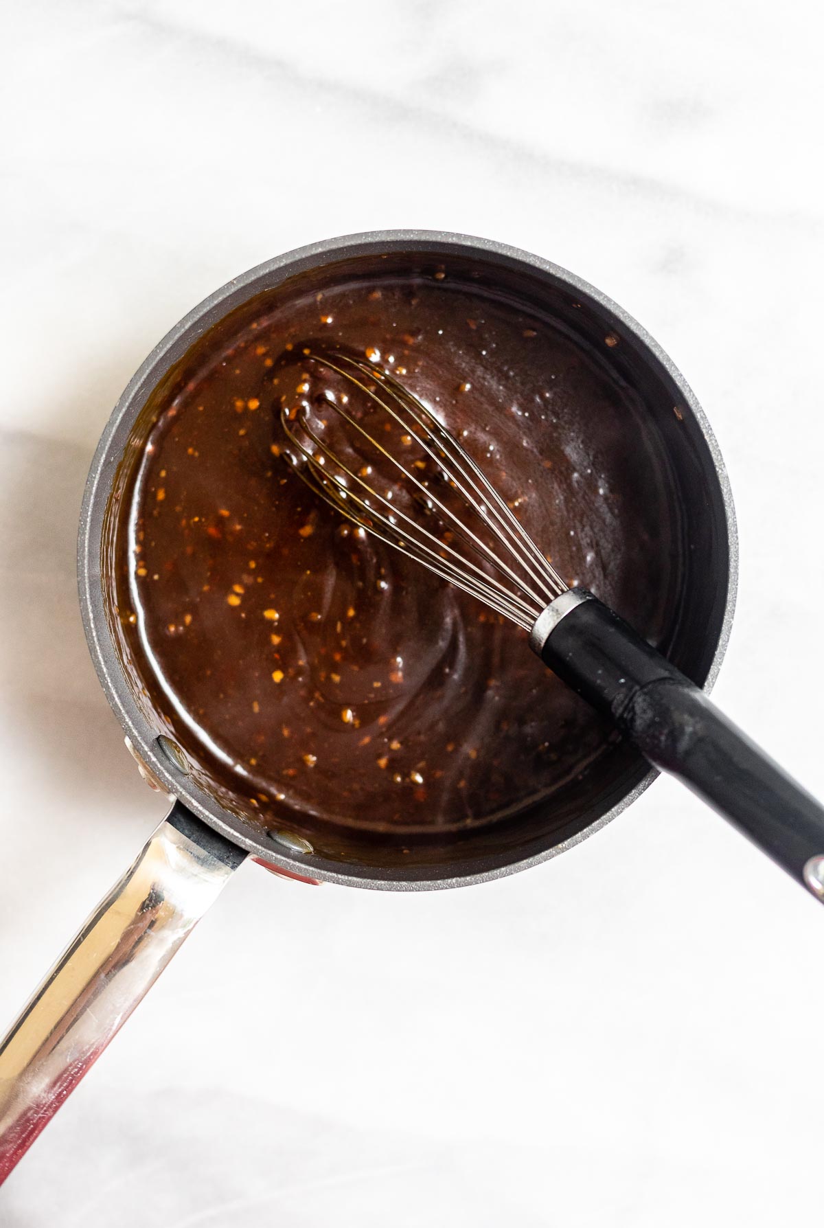 Sesame sauce in a pot with a whisk.