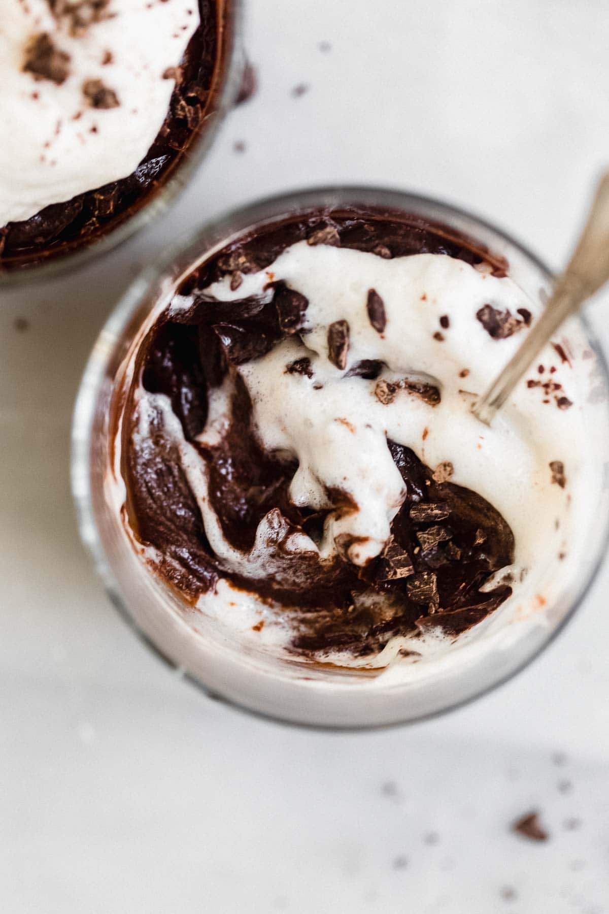 Vegan avocado chocolate mousse with whipped cream swirled on top.