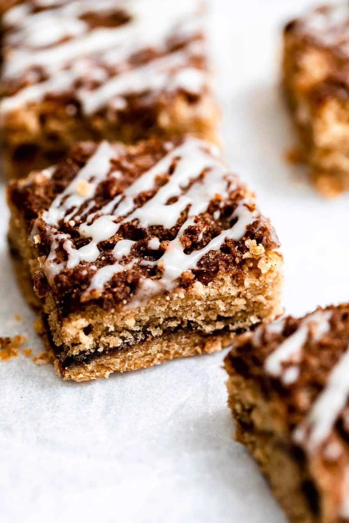 Cinnamon roll blondies sliced into squares on parchment paper. 
