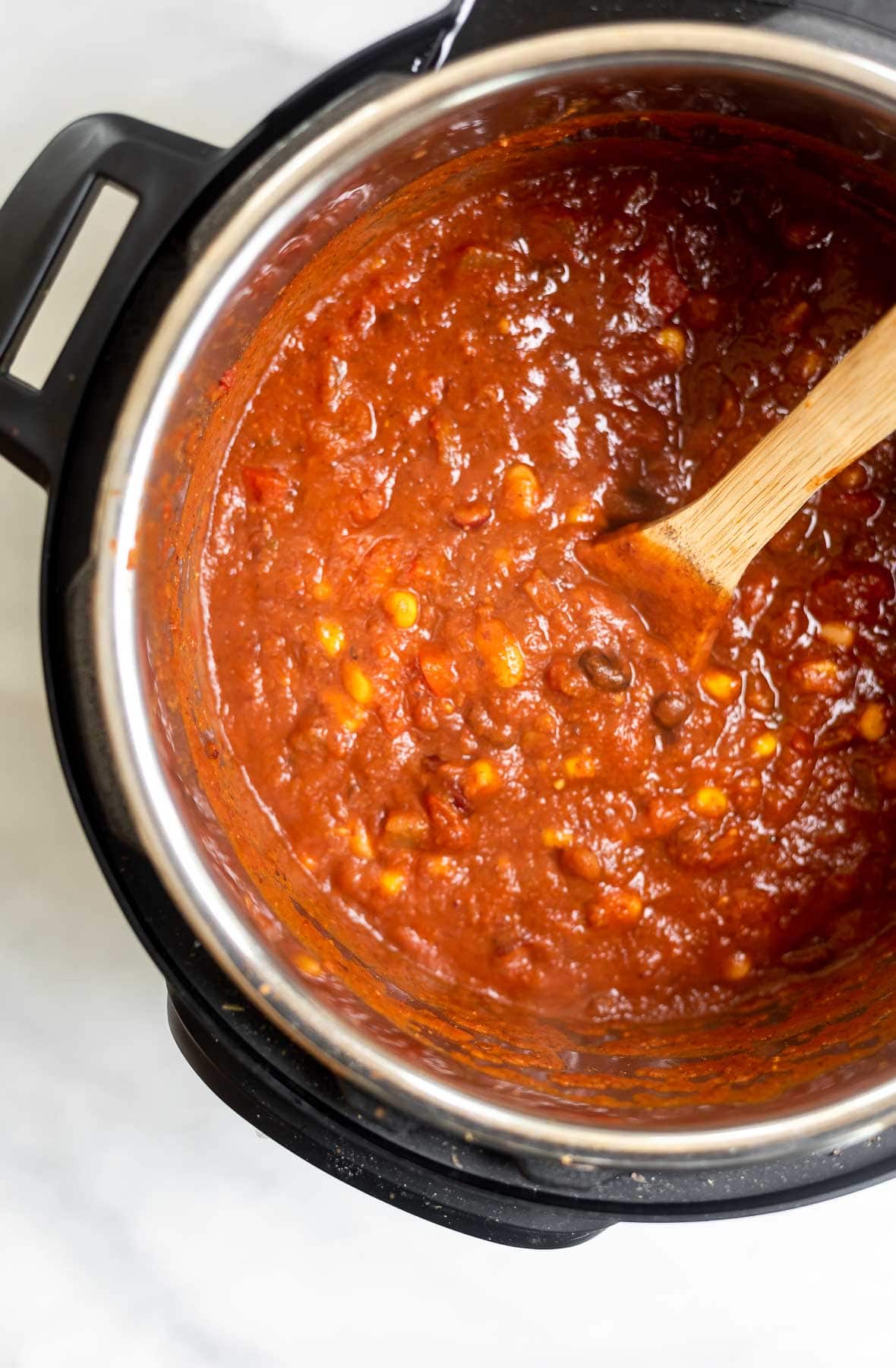 Chili in the instant pot with a spoon.
