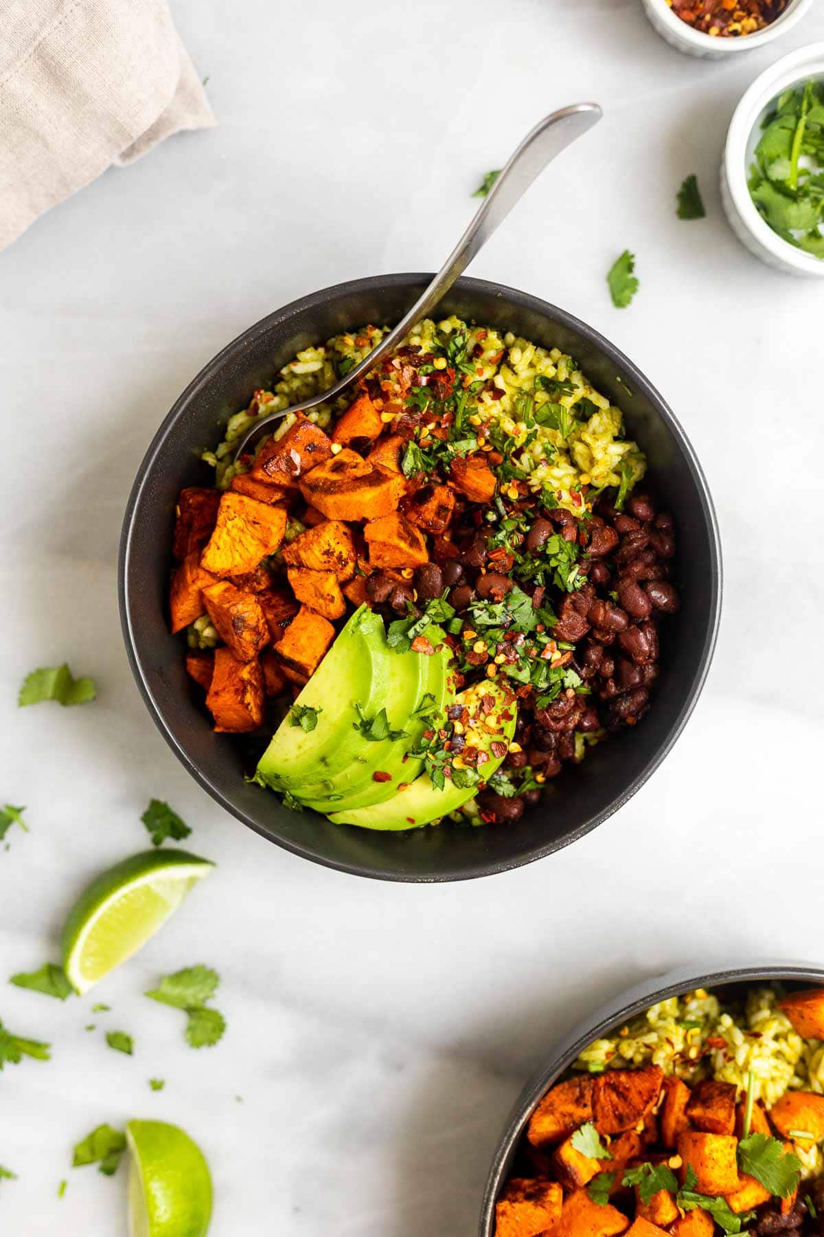 Two nourish bowls with green rice and veggies. 