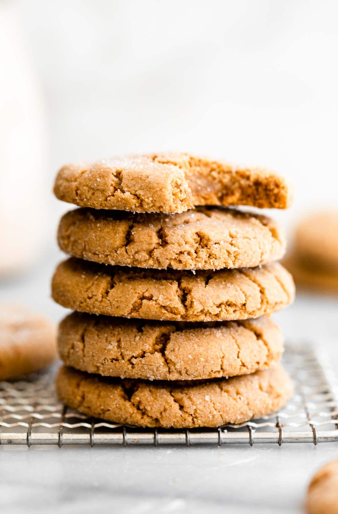 Vegan peanut butter cookies stacked one each other on a cooling rack.