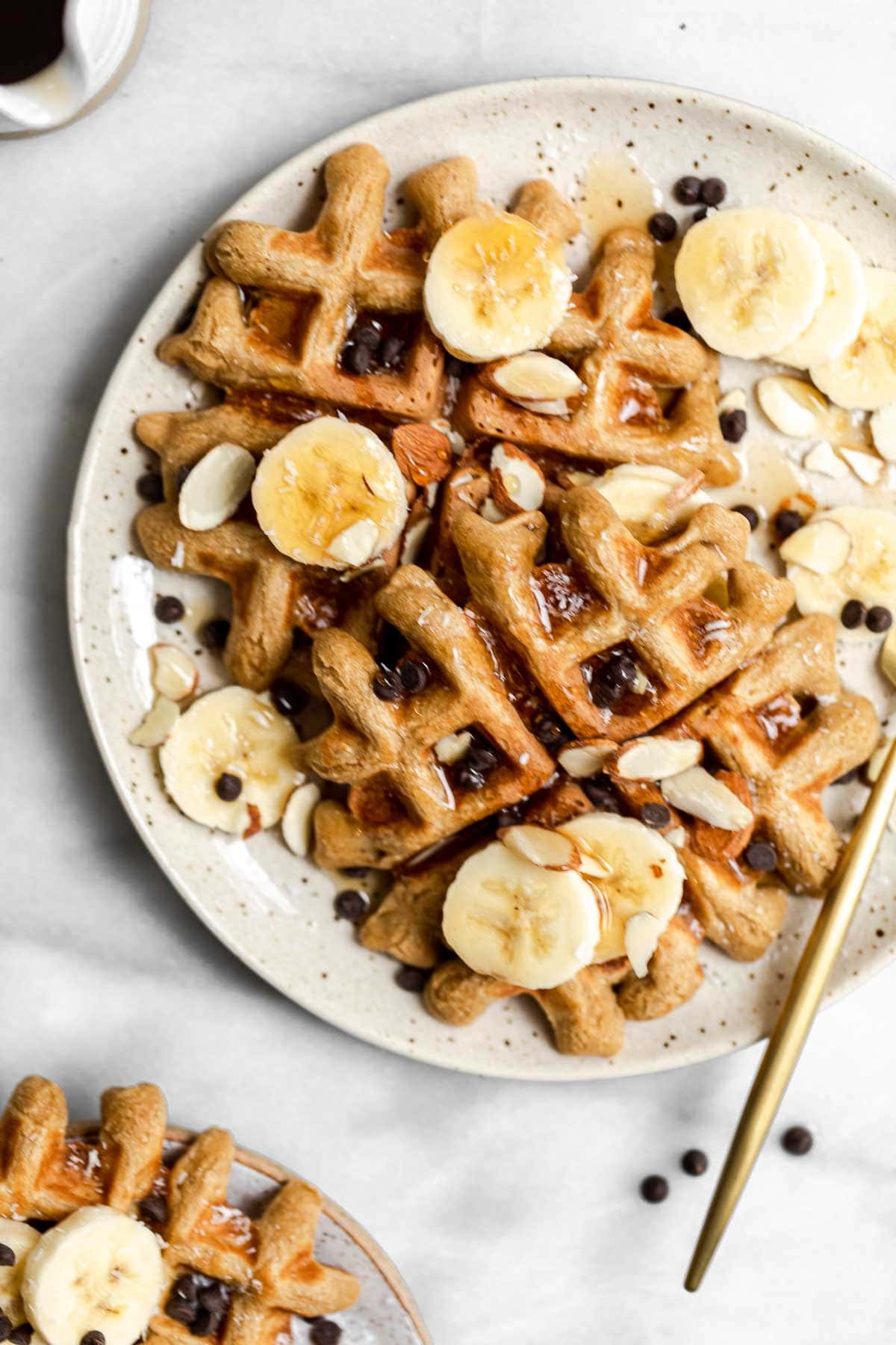 Speckled plate with peanut butter waffles and banana slices.