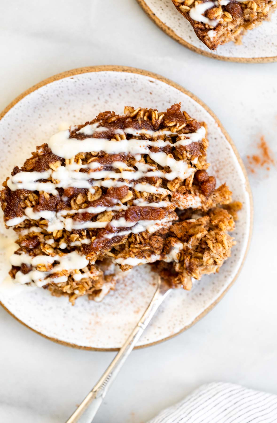 slice of cinnamon roll baked oatmeal on a plate with a fork